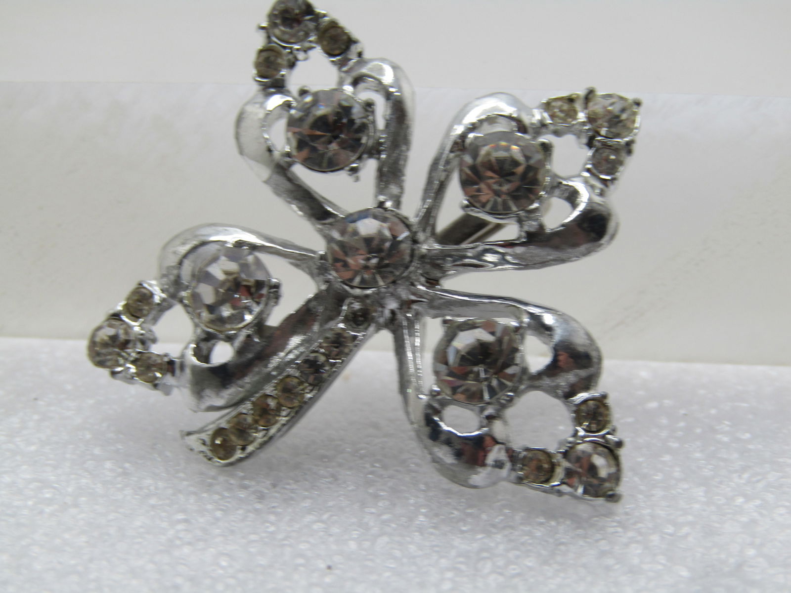 Vintage Rhinestone Leaf Brooch, 1940's-1950's: Vintage Rhinestone Leaf Brooch, 1940's-1950's. Sivler tone, This leaf has four petals and a curved stem with pave set rhinestones. The petals are pointed with rhinestones. I'd say four-leaf-clover
