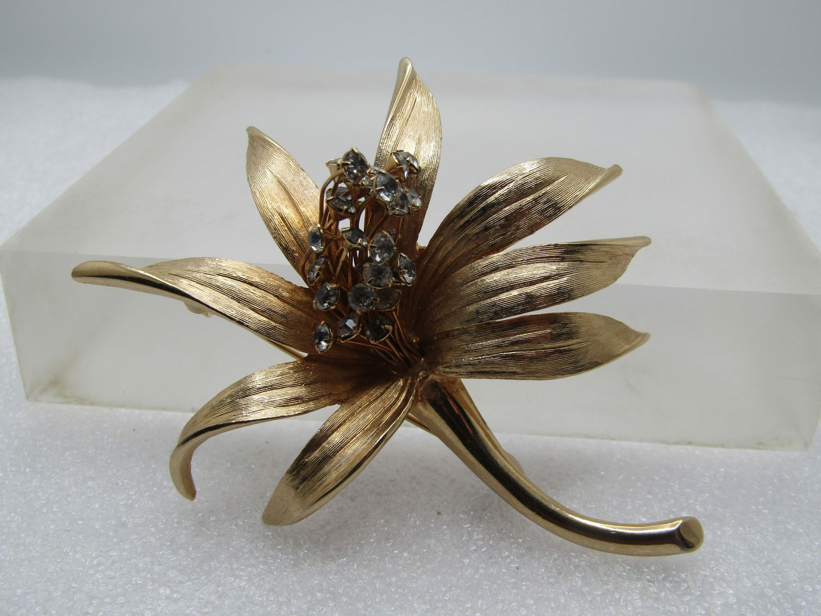 Vintage Floral Brooch, Rhinestone Cluster Center, Signed Judy Lee, 1960's-1970's: Vintage Floral Brooch, Rhinestone Cluster Center, Signed Judy Lee, 1960's-1970's. Lily type of blossom with curved and pointed textured and smooth ptals and a cluster of clear rhinestones set on