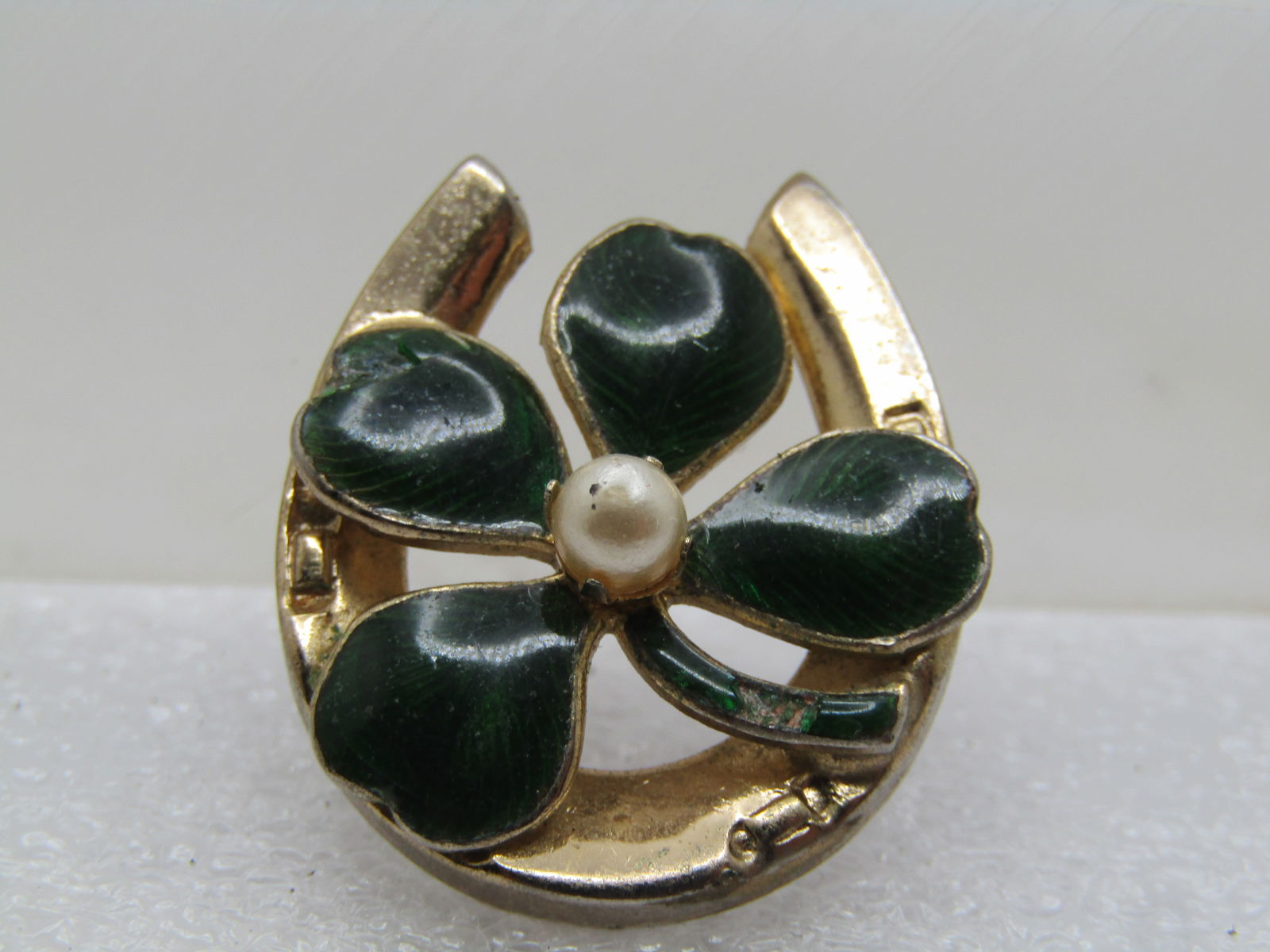 Vintage Enameled Four Leaf Clover & Horseshoe Brooch, 1950's-1960's: Vintage Enameled Four Leaf Clover & Horseshoe Brooch, 1950's-1960's. The horseshoe is gold tone and is the base with the green laminated enameling in the four leaves and a raised 4mm prong-set pearl