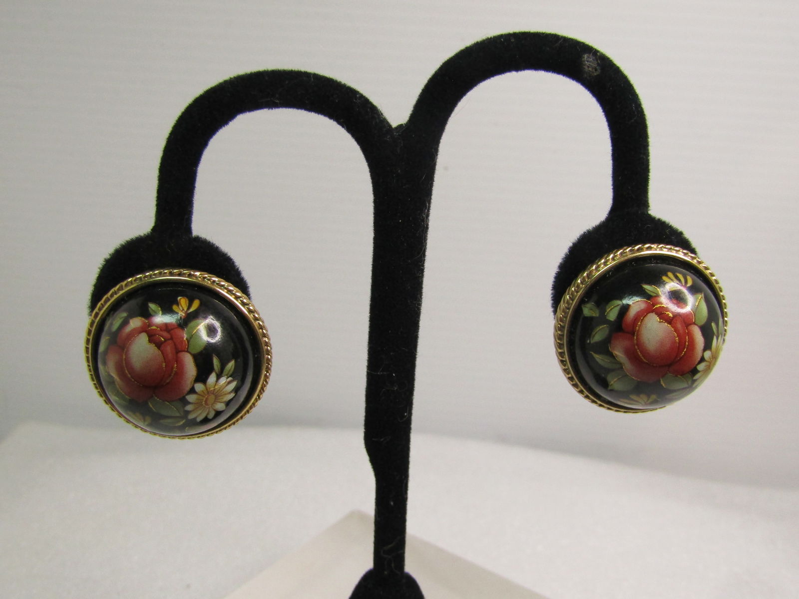 Vintage Domed Floral Clip earings, 1980's: Vintage Domed Floral Clip earings, 1980's. This are a highly domed black acryilc half round bead with a floral transfer design on them, rose, daisy, leaves and more. The black piece is appx. 23mm