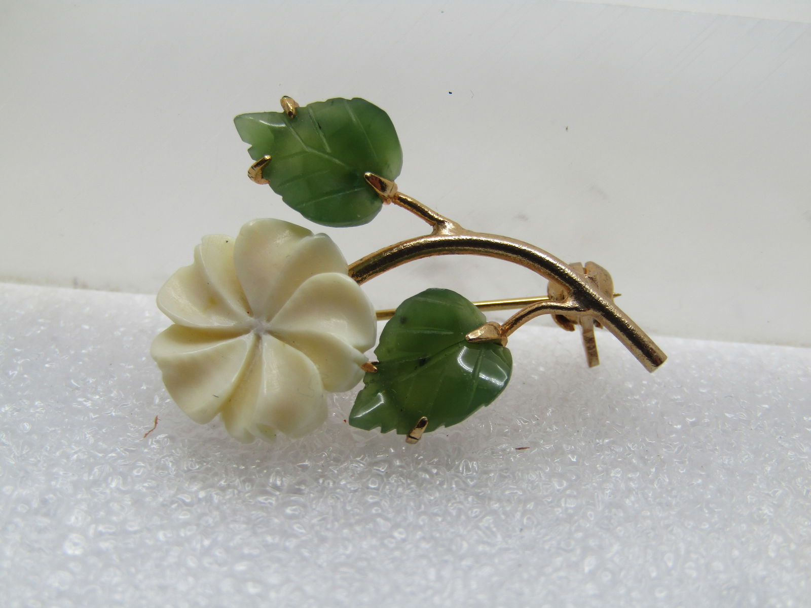 Vintage Carved Blossom & Leaves Brooch, 10kt G.F., 1960's-1970's: Vintage Carved Blossom & Leaves Brooch, 10kt G.F., 1960's-1970's. This tests as 10kt gold filled. Floral stem Brooch with white carved blossom with spiral design with two green agate carved leaves