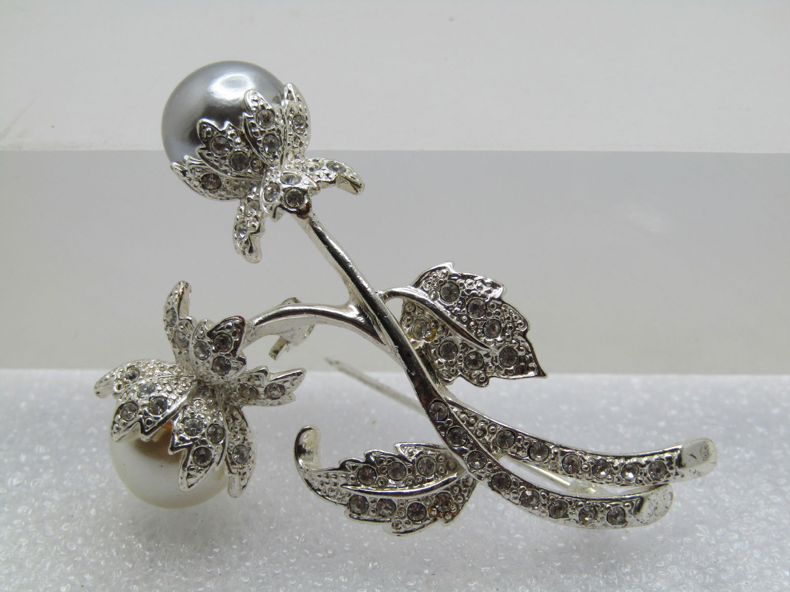 Vintage Faux Silver/White Pearl Floral Stem Brooch/Rhinestones, Avon: Vintage Faux Silver/White Pearl Floral Stem Brooch/Rhinestones, Avon marked SP. Silver plated double blossom brooch with an 11mm faux silver and white tahitian parl . Rhinestones are set in the stems,