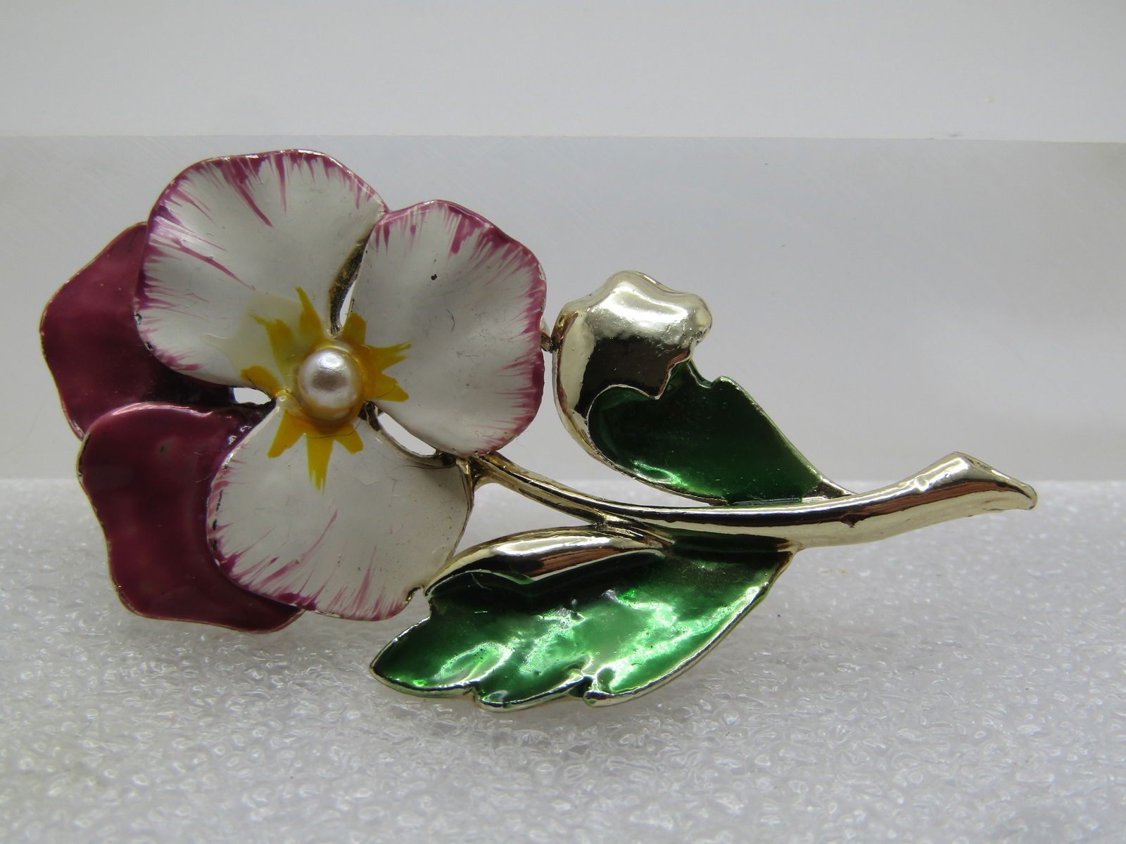Vintage Enameled Painted Pansy Brooch, 1950's-1960's, Signed Gerry's.: Vintage Enameled Painted Pansy Brooch, 1950's-1960's. Signed Gerry's. The is gold tone and a complete stem with green leaves and a lavender back petal accent with the front petals being white with