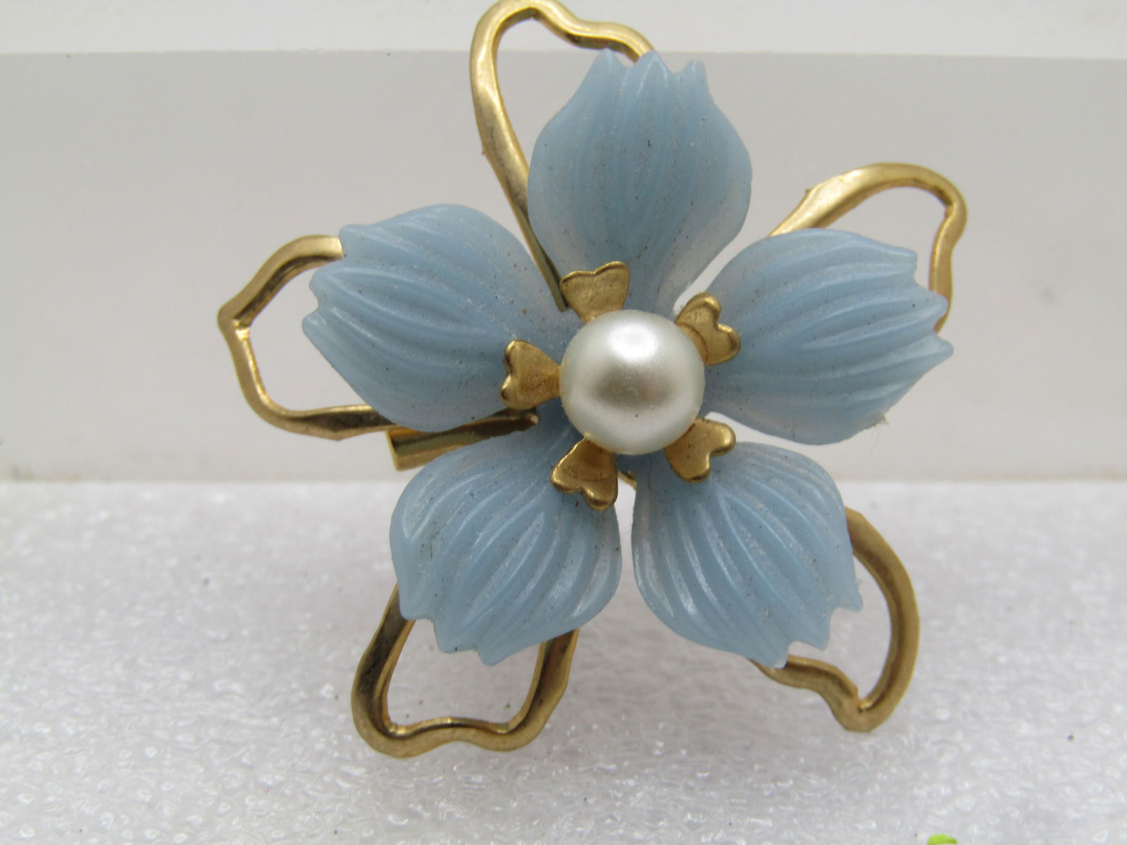 Vintage Blue Floral Brooch, Blessed Mother Charm Dangle, 1960's: intage Blue Floral Brooch, Blessed Mother Charm Dangle, 1960's. Gold tone open framed petals sit in the lower tier with raised baby blue ridged plastic shorter petals and a center appx. 5mm faux pearl