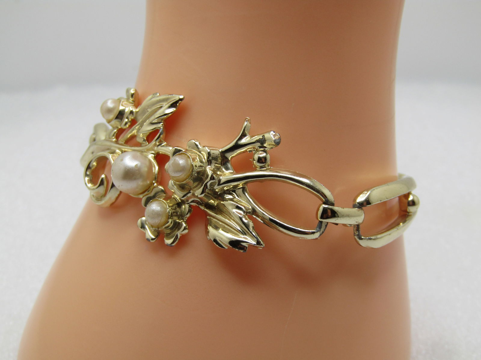 Vintage S&G Faux Pearl Bracelet, 1950's, 6.5": Vintage S&G Faux Pearl Bracelet, 1950's, 6.5. Gold tone and made in three gold tone curved sections with the top center the widest and most decorative with leaves and blossoms with faux pearls. It