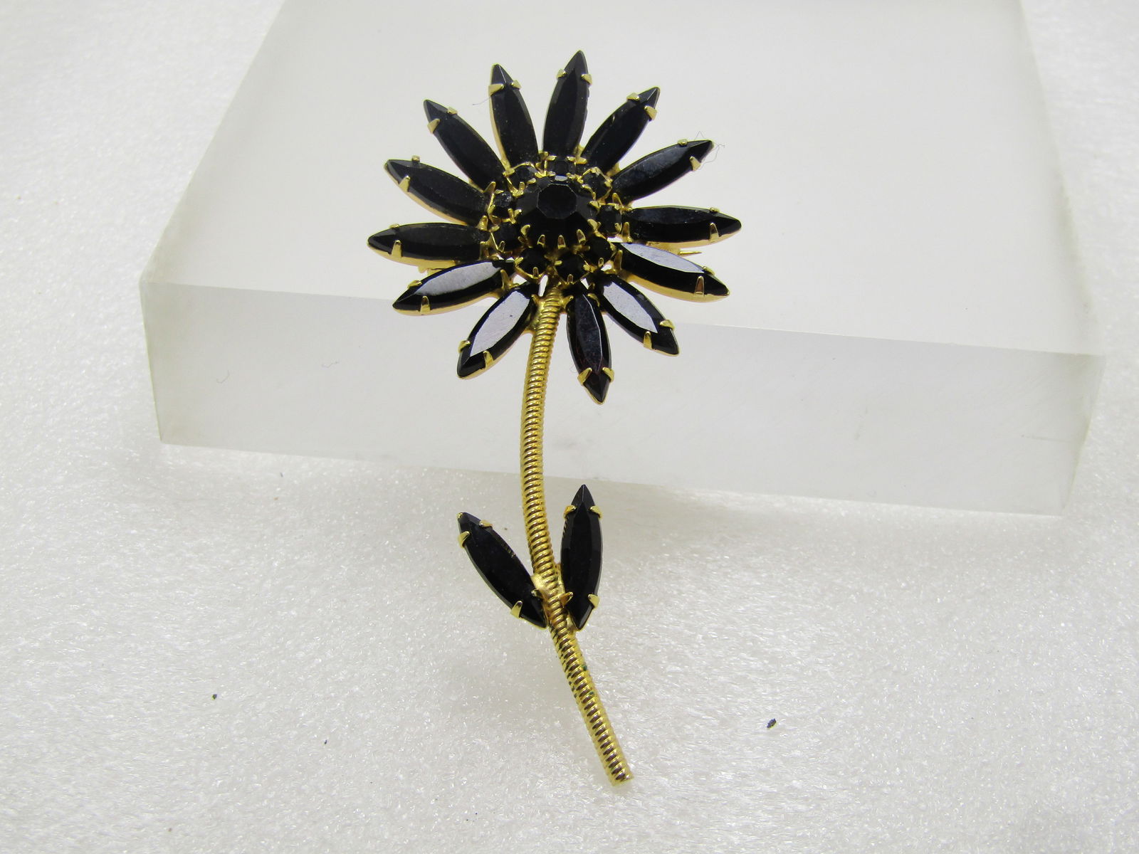 Vintage Rhinestone Floral Stem Brooch, Black Glass, 1960's: Vintage Rhinestone Floral Stem Brooch, Black Glass, 1960's. It is appx. 3" tall and 1.5" wide. Gold tone twisted look stem with two black navettes (glass) with prongs and a tiered center to the