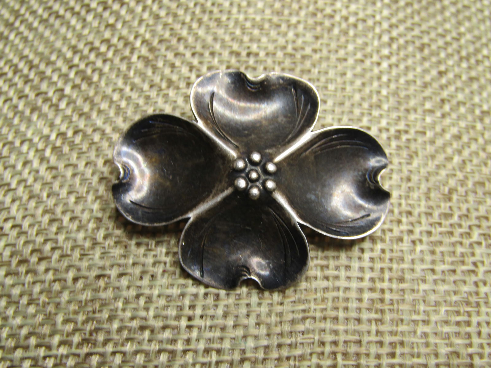 Vintage Sterling Dogwood Brooch, Signed Stuart Nye, 1930's-1950's: Vintage Sterling Dogwood Brooch, Signed Stuart Nye, 1930's-1950's. This is appx. wide and 1-1/8" tall with locking clasp. Marked sterling and tested with an appx. weight of 2.76 grams. Typical