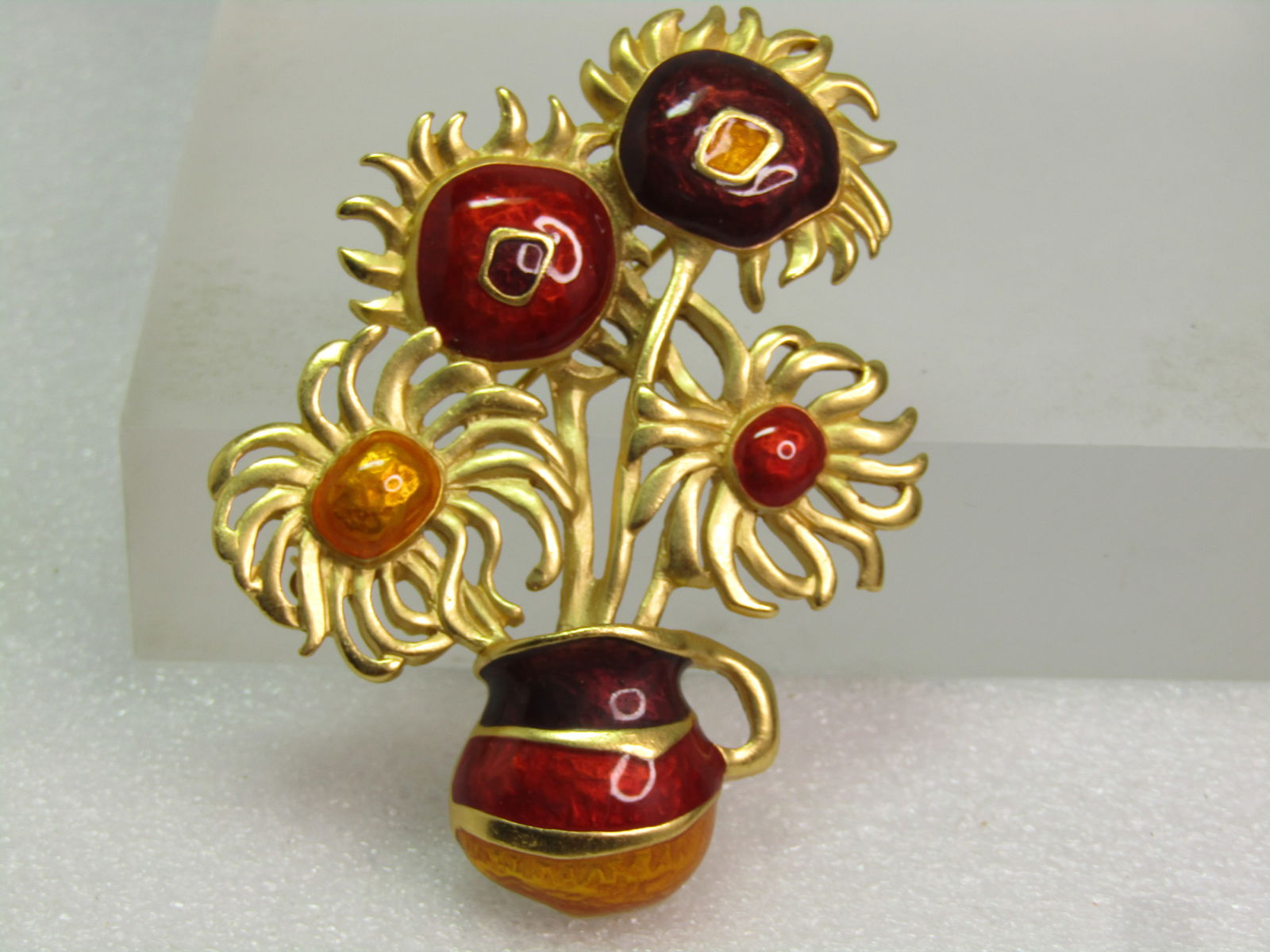 Vintage Enameled Floral Sunflower Brooch, Yves Saint Laurent for Avon, - honoring Van Gogh's: Vintage Enameled Floral Sunflower Brooch, Yves Saint Laurent for Avon, - honoring Van Gogh's sunflower painting. 1980's-1990's. The brooch is in deep red, orange, deep purple/maroon inwhich a clear st