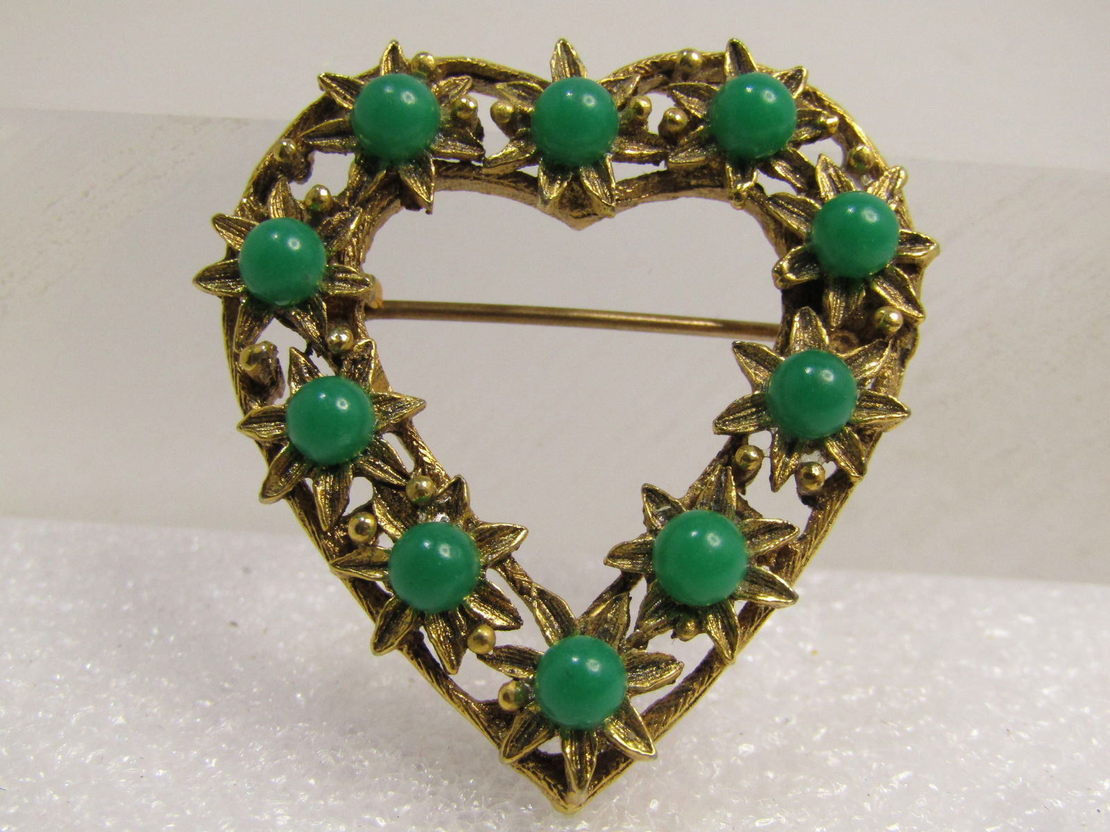 Vintage Green Beaded Heart Brooch, Floral Theme, 1960's: Vintage Green Beaded Heart Brooch, Floral Theme, 1960's. Gold tone heart that is appx. 1-3/8" tall and 1.25" wide. there are blossoms set on the heart frame with open areas under the blossoms that