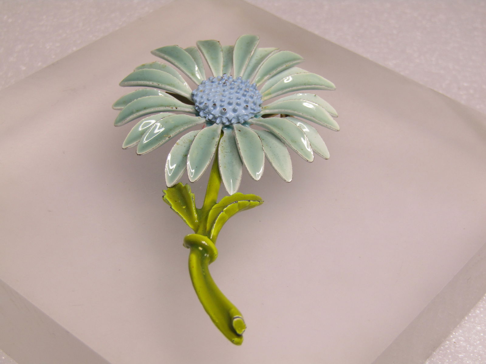 Vintage Blue Enameled Floral Stem Brooch, 1960's: Vintage Blue Enameled Floral Stem Brooch, 1960's. Dahlia daisy style flower with a seafoam color on the metals and a baby blue dotted center and green curved stem with two leaves. It is appx.
