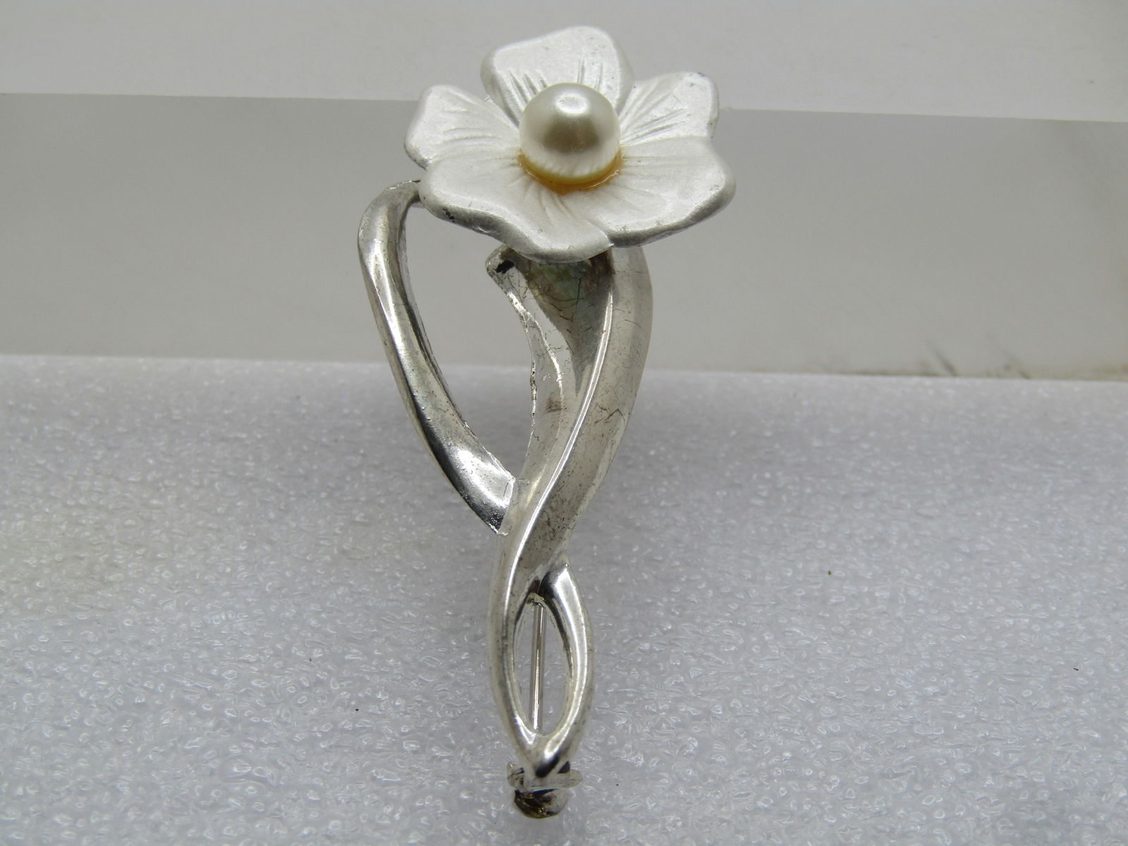 Vintage Pearly Flower Stem Brooch, Faux Pearl, 1980's, 2.25": Vintage Pearly Flower Stem Brooch, Faux Pearl, 1980's, 2.25". Long silver tone stem and ridge and curved leaf/stem with a pearly 7/8" five petal white pearly blossom and a 6mm faux white pearl in the