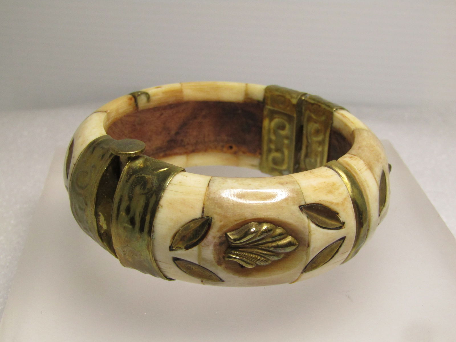 Vintage Brass & Carved Bone Bracelet, Tribal, Hinged, Pin Clasp, 6.75", 1970's-1980's: Vintage Brass & Carved Bone Bracelet, Tribal, Hinged, Pin Clasp, 6.75", 1970's-1980's. This is rounded on the outer edge with inlaid brass leaves in four sections around the wrist and brass accent