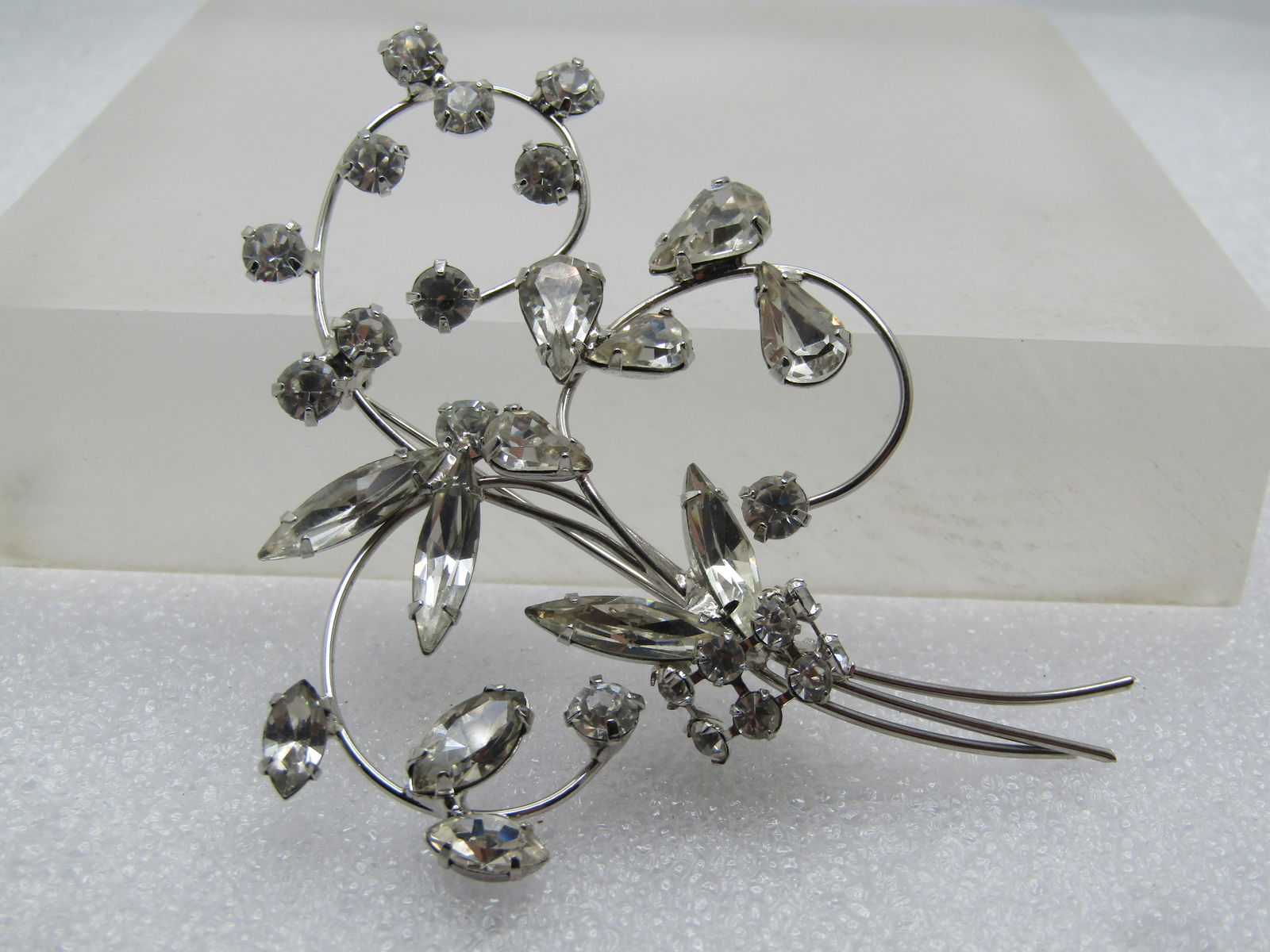 Vintage Clear Rhinestone Floral Stem Brooch, 1960's, 3": Vintage Clear Rhinestone Floral Stem Brooch, 1960's, 3" tall and 2.25" wide. Silver tone coils with clear marquise/navette stones that range from 7mm long to 14.5mm. Pear shaped stones are appx. 6.5mm
