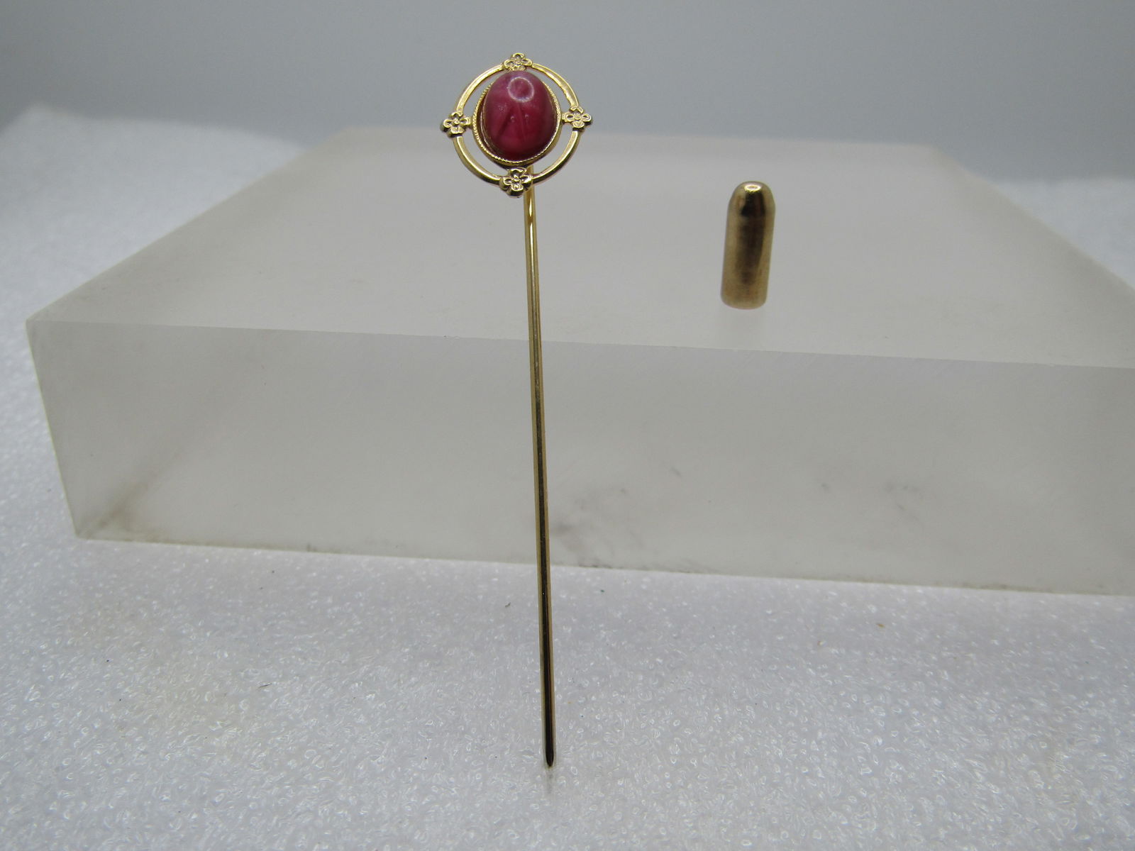 Vintage Synthetic Pink Star Sapphire Stick Pin, 1960's-1970's: Vintage Synthetic Pink Star Sapphire Stick Pin, 1960's-1970's. Gold tone and appx. 2.5" long with a safety cap. the top has an oval synthetic pink star sapphire that is appx. 8mm by 5.5mm oval set on