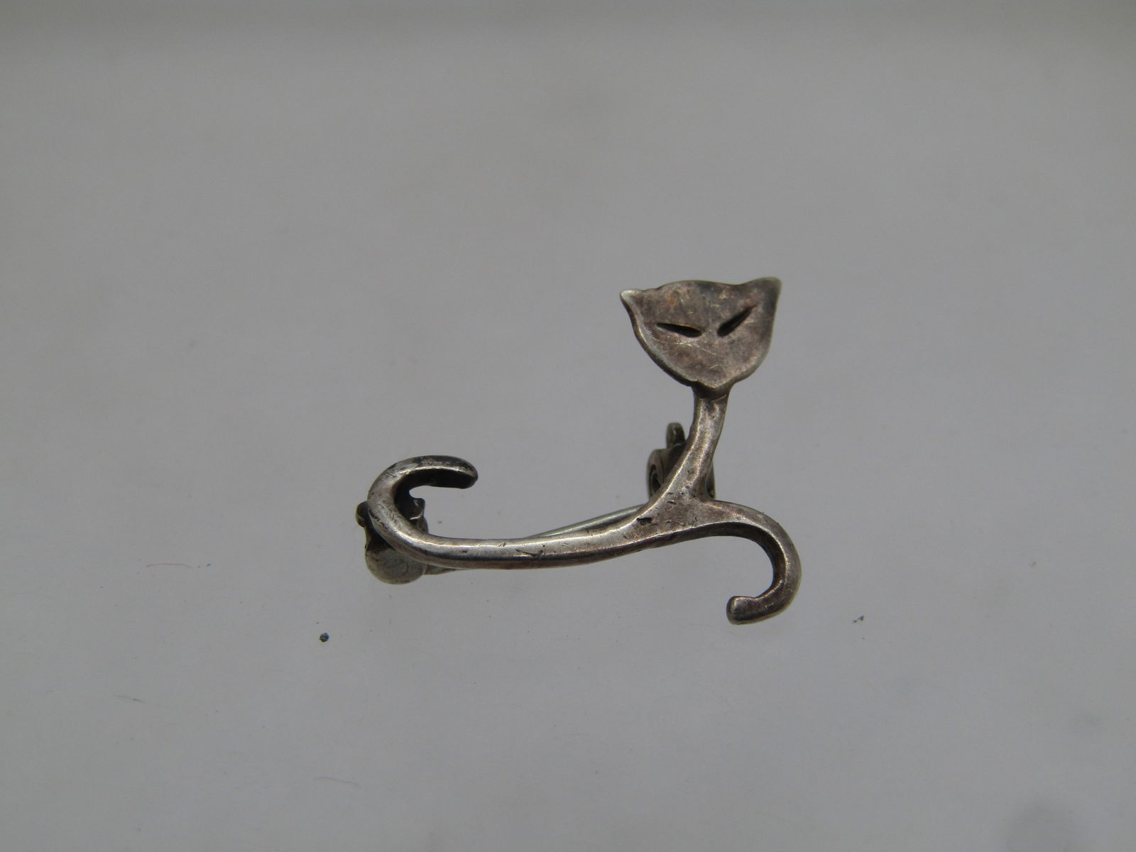Vintage Sterling Siamese Cat Brooch, Abstract/Mod Design, 1960'S-1970's.: Vintage Sterling Siamese Cat Brooch, Abstract/Mod Design, 1960's-1970's. It is 3/4" wide and 5/8" tall. Curled designs make up the cat's body, tail and front paws and the heat is a solid flat piece wi