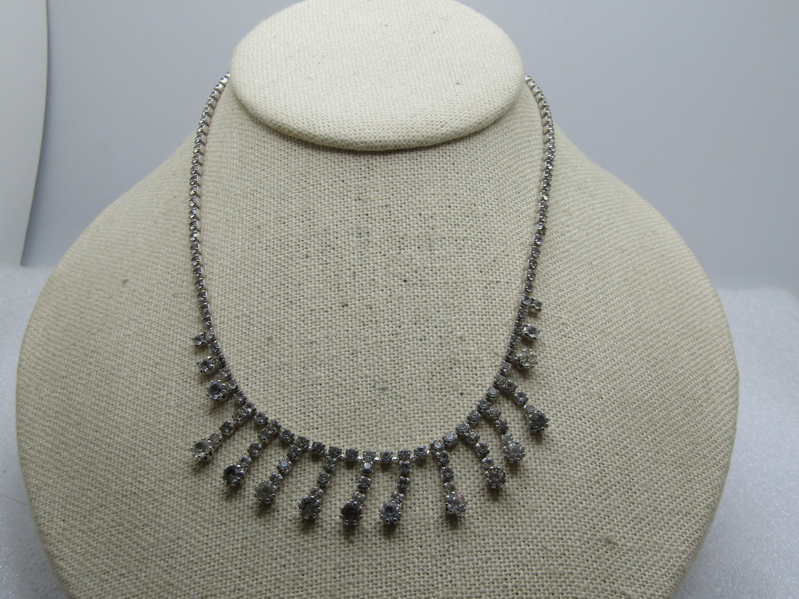 Vintage Clear Rhinestone Drop Neckace 15", 1960's: Vintage Clear Rhinestone Drop Neckace 15", 1960's. Silver tone with a brass hook clasp. There are clear stones, appx. 2.5mm with drops across the front center that areappx. 3mm with a larger appx. 4mm