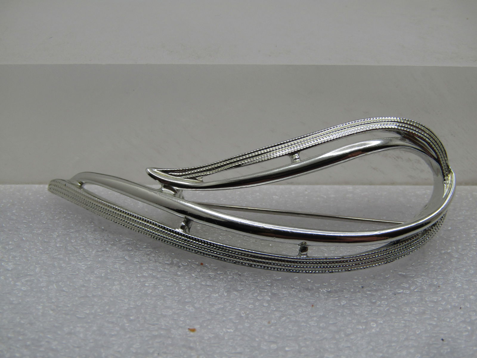 Vintage Wispy Looped Brooch, Sarah Coventry, 1960's-1970's: Vintage Wispy Looped Brooch, Sarah Coventry, 1960's-1970's. Silver tone with a smooth and shiny loop and a textured loop. It is appx. 2.5" tall and 1" wide. Long locking clasp. Very clean and very goo