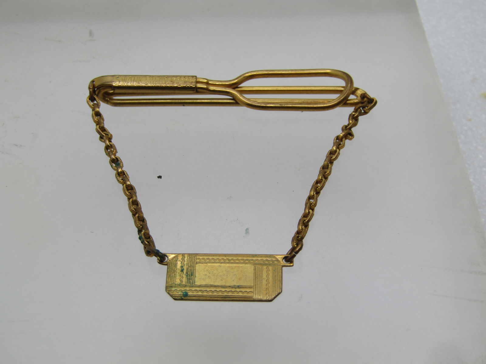 Vintage Swank Tie Park & Chain, Art Deco Engravable, 1930's: Vintage Swank Tie Park & Chain, Art Deco Engravable, 1930's. 10kt gold plated, signed Swank with patent no. 1865995 - a 1931 patent. It is appx. 2,25" wide and 1.75" at the dangle in the center which