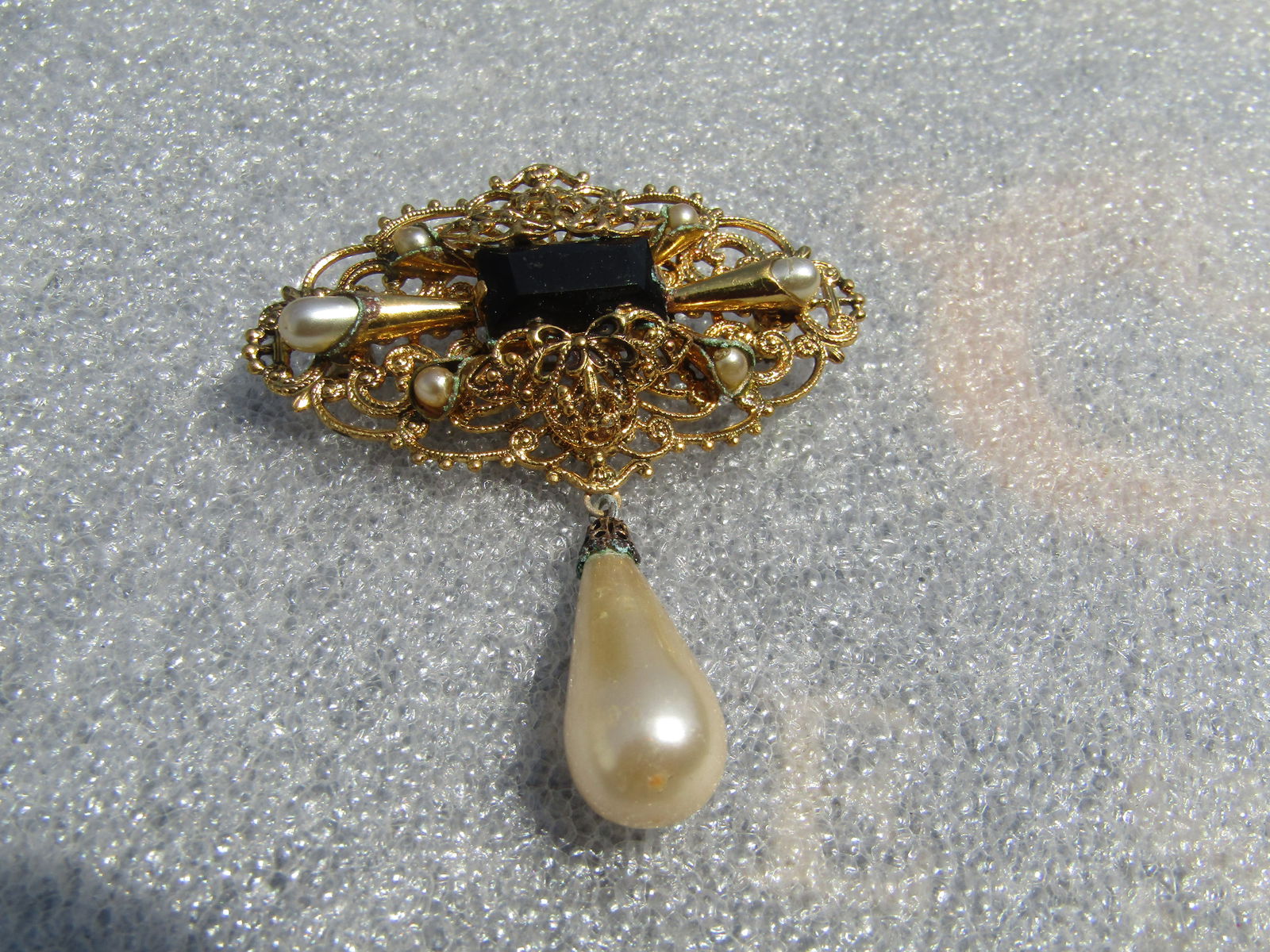 Vintage Filigree Faux Pearl/Black Stone Brooch, Drop Pearl, 1970's-1980's: Vintage Filigree Faux Pearl/Black Stone Brooch, Drop Pearl, 1970's-1980's. This has a filigree base on top with scalloped edges and milgrain finish. thre are two conical accents, one on each side with