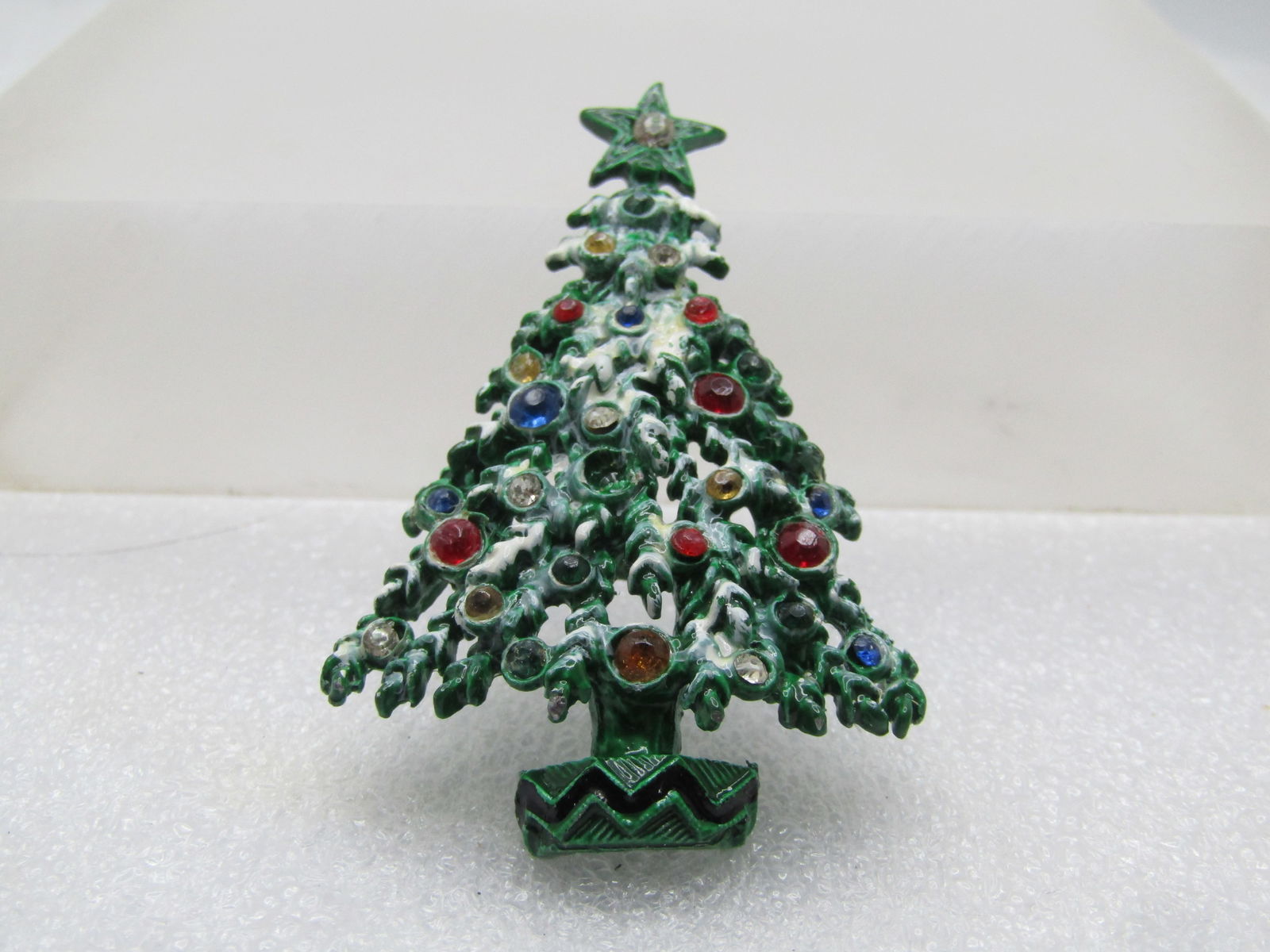 Vintage Green Enameled Christmas Tree Brooch, Rhinestones, 1970's: Vintage Green Enameled Christmas Tree Brooch, Rhinestones, 1970's. Enameled in green with snowy white accents. It has mixed round size nd colored rhienstones throughout the tree with a clear stone set