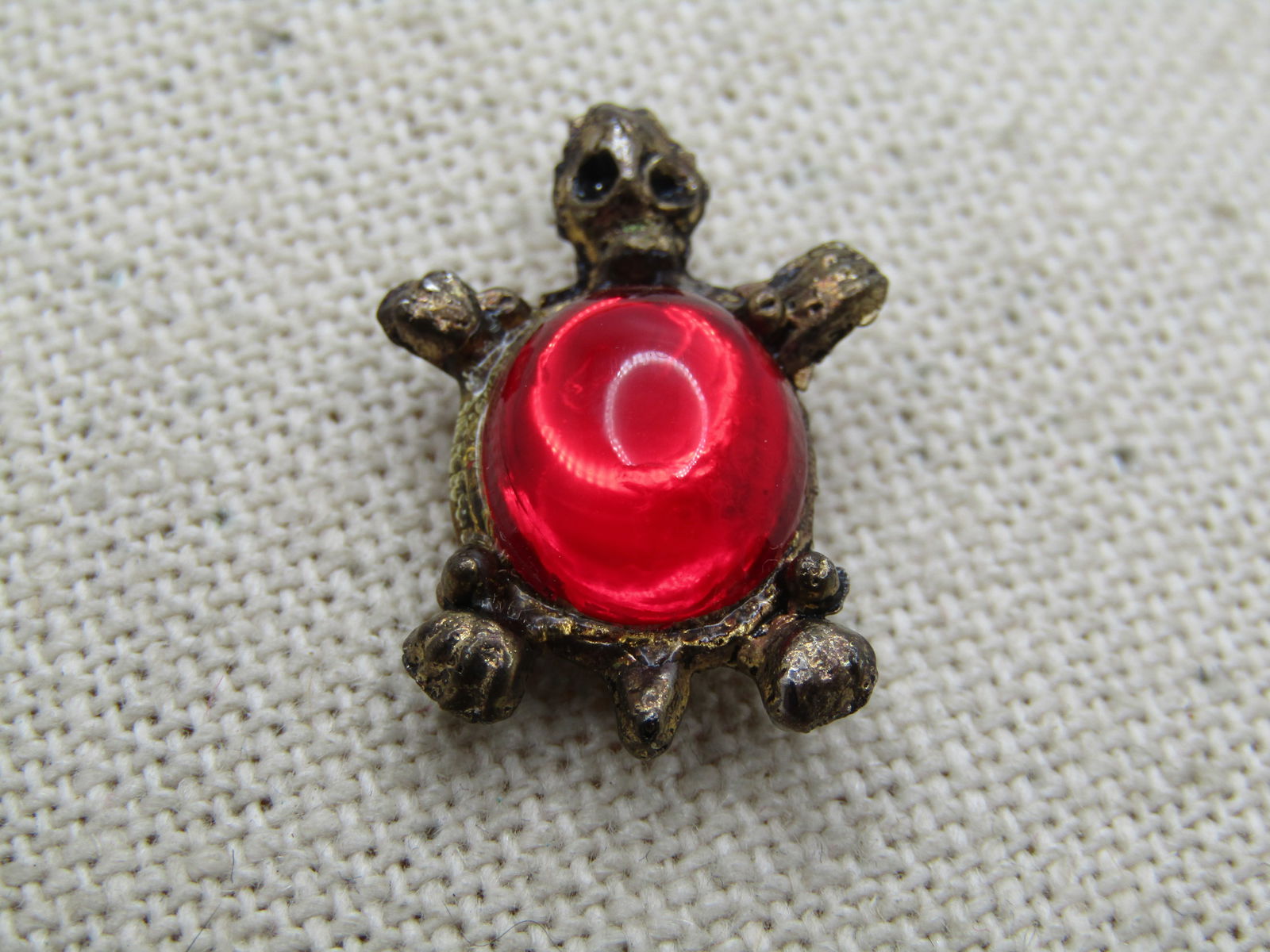 Vintage Red Jelly Belly Turtle Tack Pin 1960's-1970's.: Vintage Red Jelly Belly Turtle Tack Pin 1960's-1970's. The turtle is appx. 1" tall by 3/4" wide. Its shell is a 10.5mm by 8.5mm red jelly belly glass stone. It is a brassy gold tone finish with