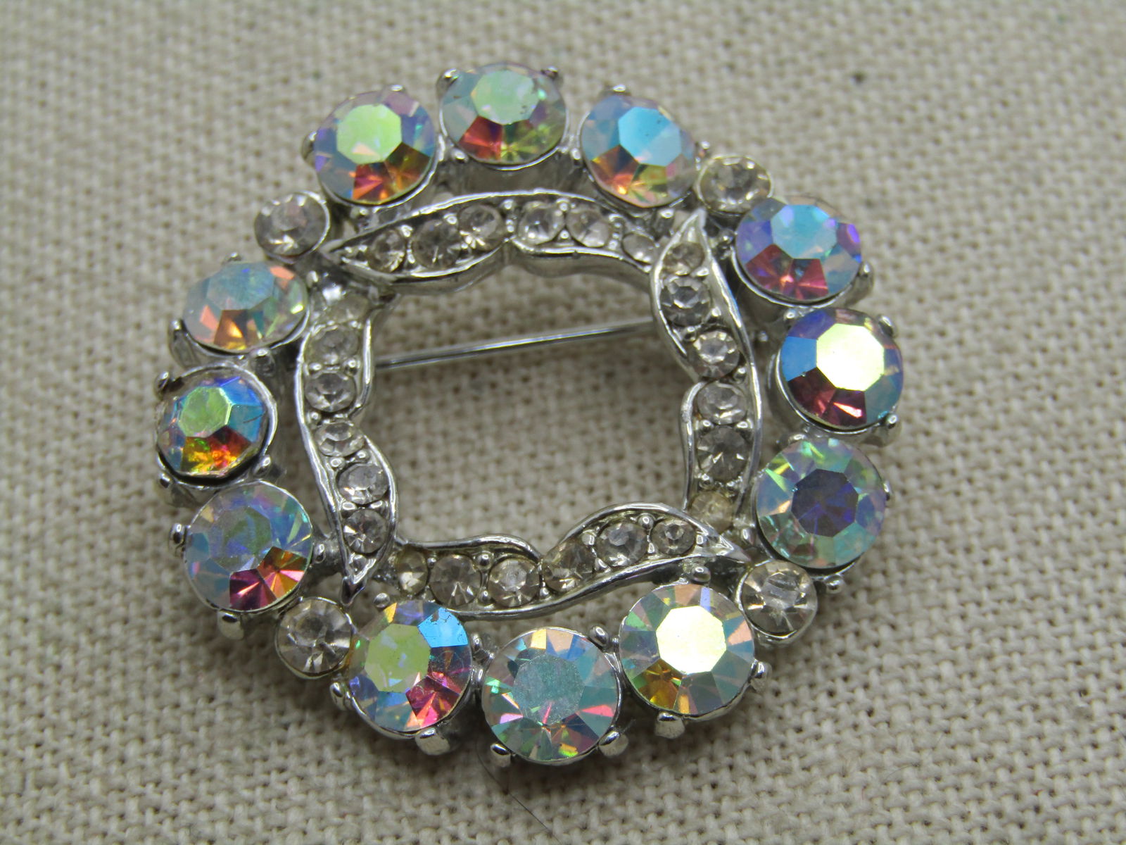 Vintage Aurora Borealis Circle Brooch, 1960's: Vintage Aurora Borealis Circle Brooch, 1960'sDouble circle with pastel aurora borealis clear rhinestones on the outher edges that area appx. 3MM wide and 6mm wide with a inner clear rhinestone frame.