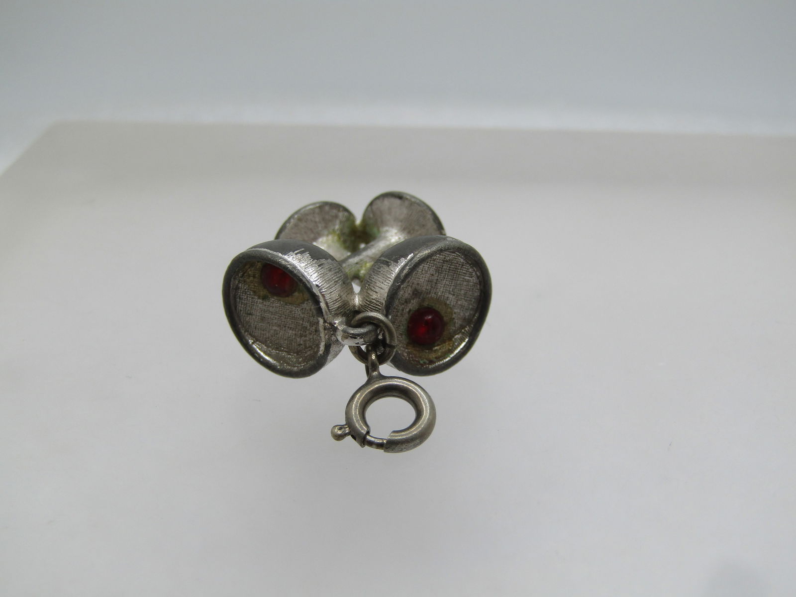 Vintage Monet Champagne Glasses Charm Pendant, 1960's: Vintage Monet Champagne Glasses Charm Pendant, 1960's. This has a spring ring to add to a charm bracelet or use as a pendant. It is two glasses crossed at the stem, each glass has a red 2.5mm stone