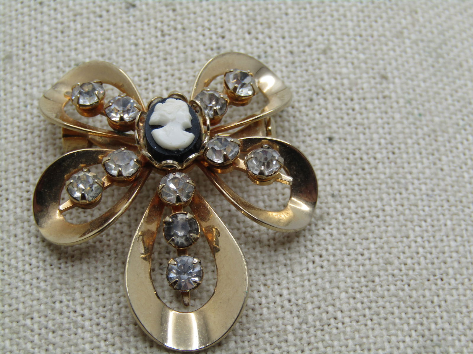Vintage Cameo Rhinestone Looped Brooch Pendant, 1960's: Vintage Cameo Rhinestone Looped Brooch Pendant, 1960's. Gold tone with five open curved petals that have two clar rhinestones that are appx. 4mm ech and in the center is a small oval black and white c