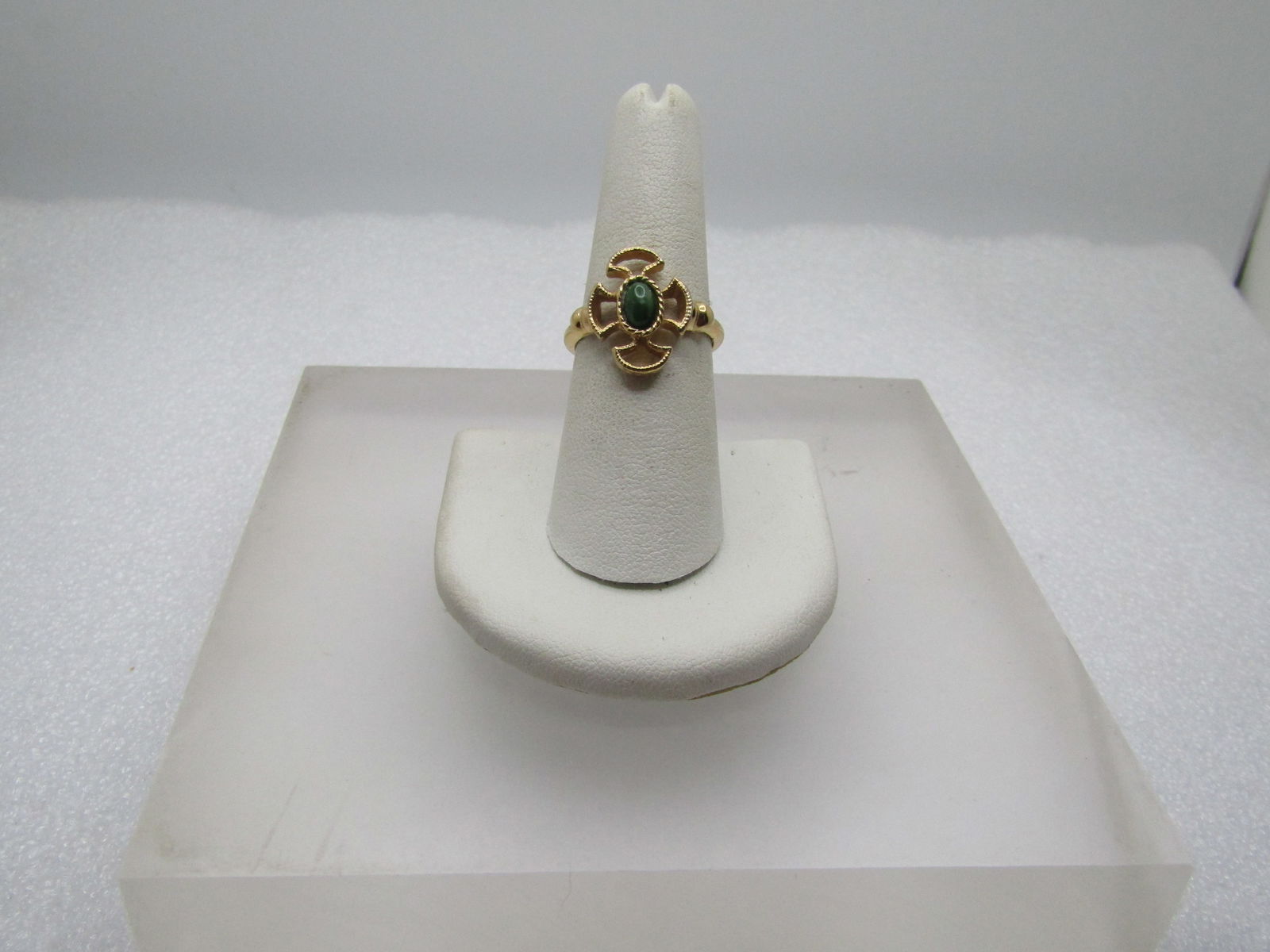 Vintage Avon Baroness Faux Jade Ring, Adj. Sz. 5.5-7. 1970's: Vintage Avon Faux Jade Ring, Adj. Sz. 5.5-7. 1970's. Gold tone ring with an open cross-like top wth a center faux oval jade stone. The top of the ring is appx. 16mm by 12.5mm. Decorate top to the