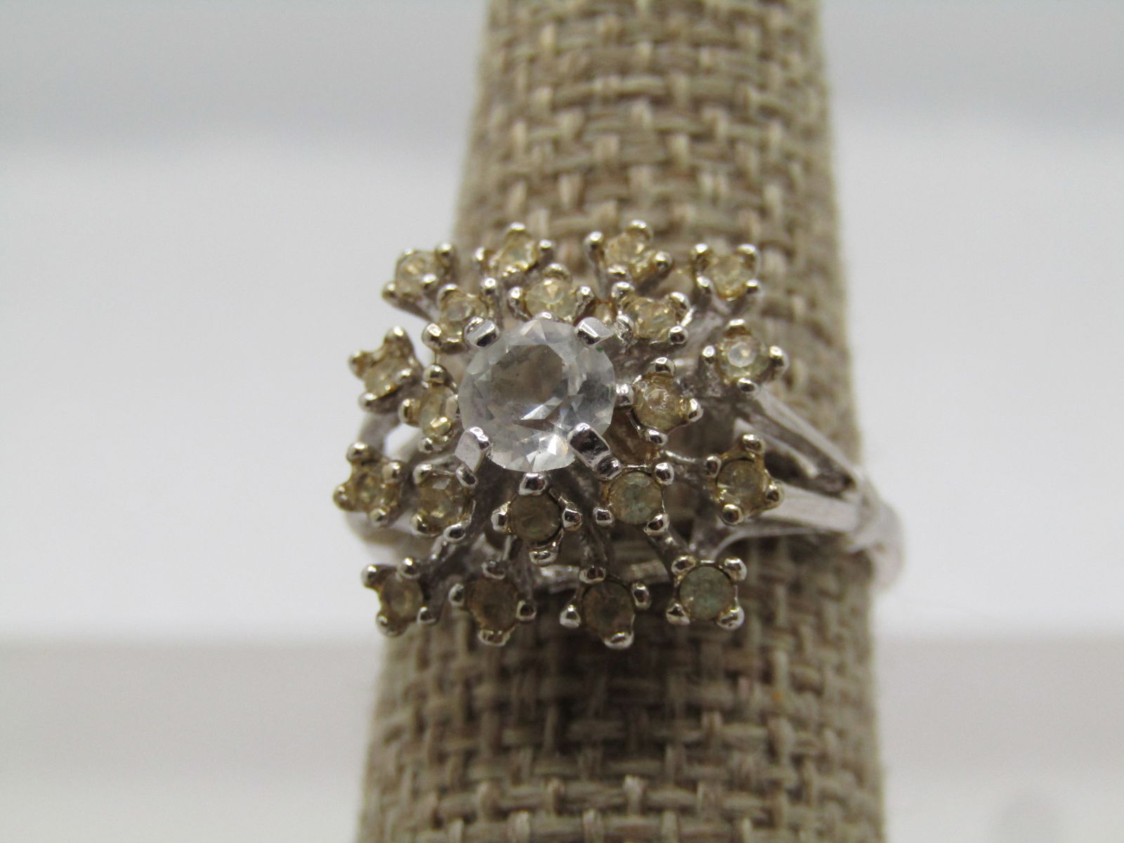 Vintage Clear Rhinestone Cluster Ring, Sz 8. , 1960's-1970's: Vintage Clear Rhinestone Cluster Ring, Sz 8. , 1960's-1970's. Silver tone ring with a square shaped top with tiered clear rhinestones that reach out from the main 5mm stone set highest on top. Two tie