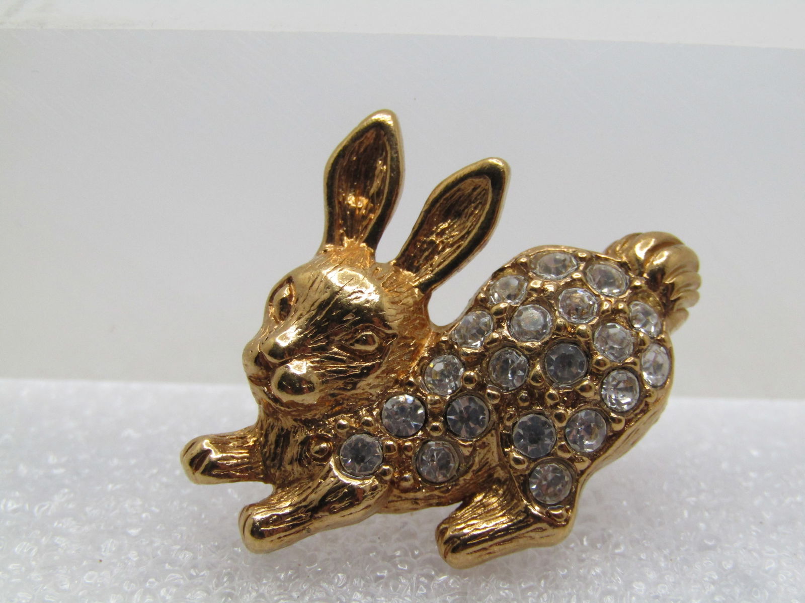 Vintage Rhinestone Rabbit Tack Pin, Avon, 1970's: Vintage Rhinestone Rabbit Tack Pin, Avon, 1970's. Gold tone with clear rhinestone - bunny has its butt up in the back - very cute. It is appx. 1.25" wide and 1" tall. Gold tone. Very clean and