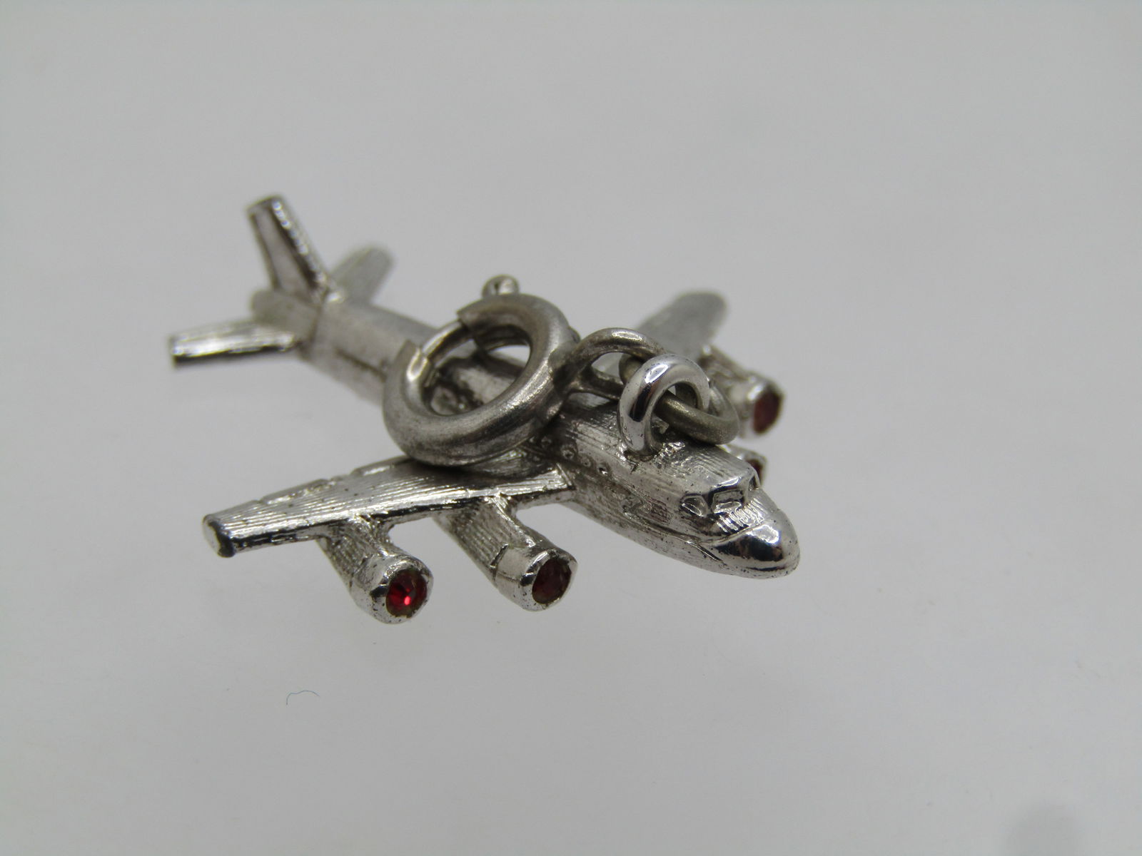 Vintage Monet Airplane Charm/Pendant, Spring Ring, 1960's: Vintage Monet Airplane Charm/Pendant, Spring Ring, 1960's. The plane is appx. 1" and silver tone. It has a spring ring for easy attaching to a charm bracelet or chain. Signed Monet on the spring