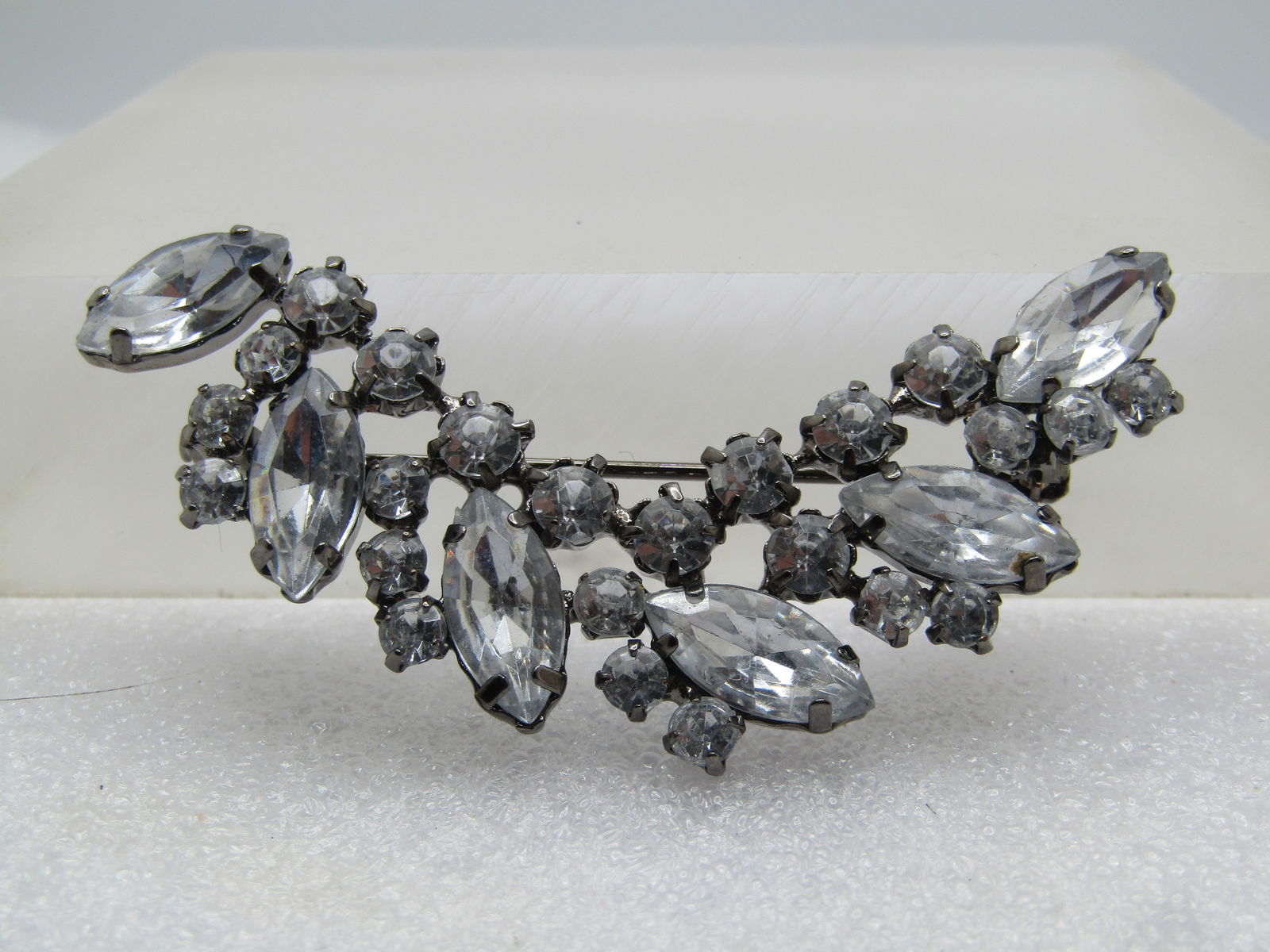 Vintage Clear Rhinestone Curved Brooch, Marquise/Round stones, 1980's-1990's: Vintage Clear Rhinestone Curved Brooch, Marquise/Round stones, 1980's. the stones are clear acryic stones set in a titanium toned setting. closed black with prongs. The marquise stones are appx. 14mm