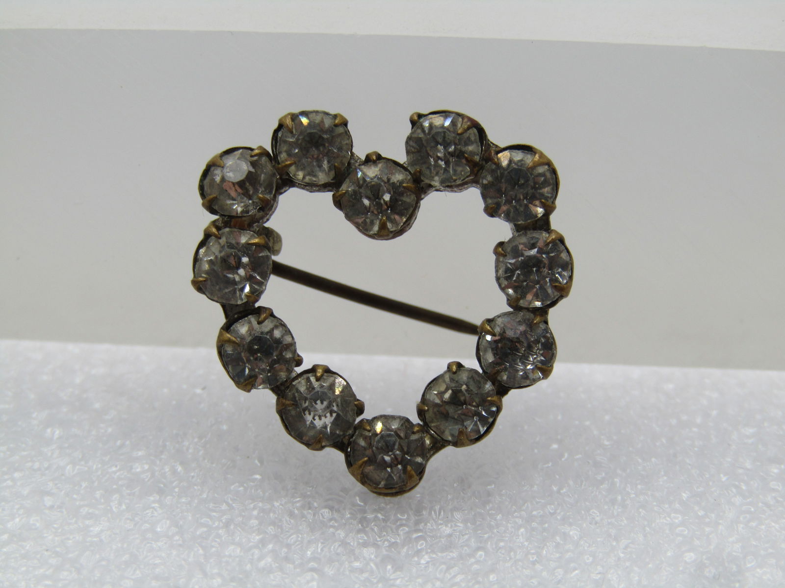 Vintage Rhinestone Heart Brooch, C-Clasp, 1920's-1930's: Vintage Rhinestone Heart Brooch, C-Clasp, 1920's-1930's. Clear stones set in a brassy gold tone setting with prongs holding the stones. The brooch is appx. 1" tall and 7/8" wide. It is not signed