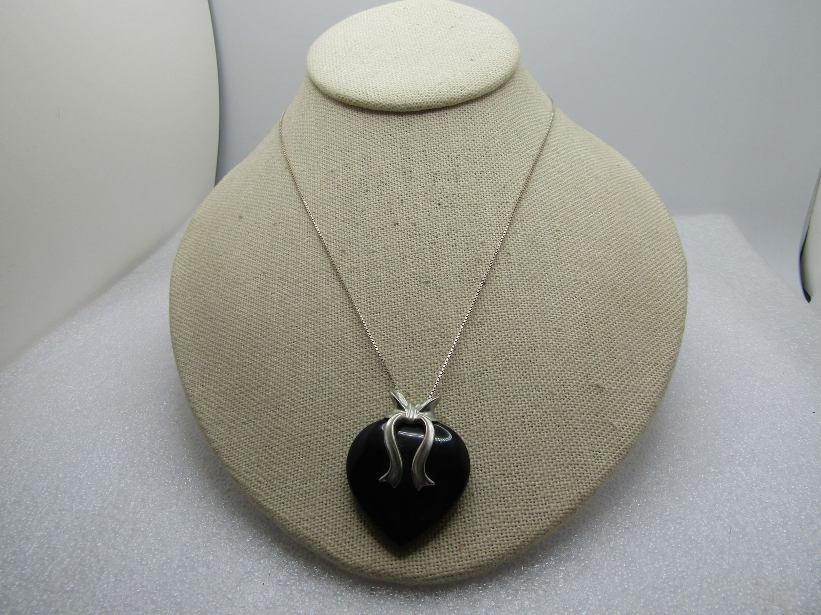 Vintage Sterling Black Onyx Heart Ribbon Necklace, 24". 1980's-1990's: Vintage Sterling Black Heart Ribbon Necklace, 24". 1980's-1990's. The pendant is a black onyx puffy heart that is appx. 1.25" tall and wide with a flowing sterling bow that sits on top and over the