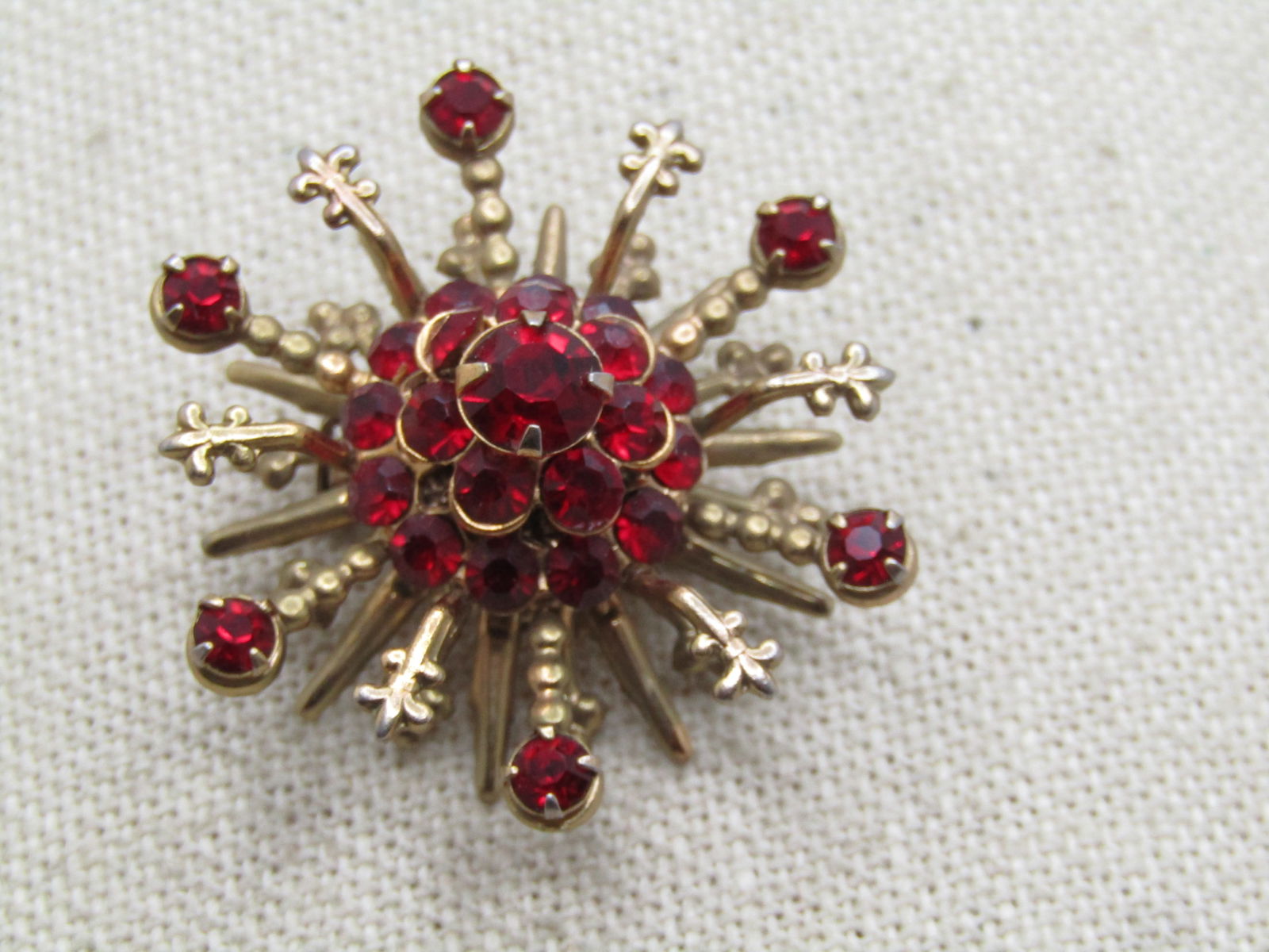 Vintage Red Rhinestone Tiered Brooch, 1940's-1950's: Vintage Red Rhinestone Tiered Brooch, 1940's-1950's. Four tiers with the bottom layer being a 1-1/8" tier of pionted rays alternating with slightly shorter rays with three beads at the end. The