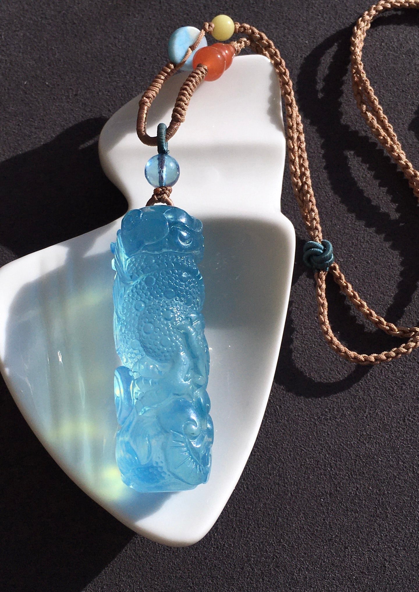Aquamarine Carved Pendant: Title: Aquamarine Carved Pendant Description: This turquoise carving pendant captures the tranquility of the ocean with its enchanting Saint Mary blue color. The transparency of the crystal allows
