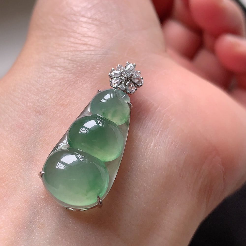 Ice-floating flower jadeite lucky bean pendant: Title: Ice-floating flower jadeite lucky bean pendant Description: This pendant captures the essence of elegance with its exquisite ice flower design. The delicate and lustrous base exudes a fresh and