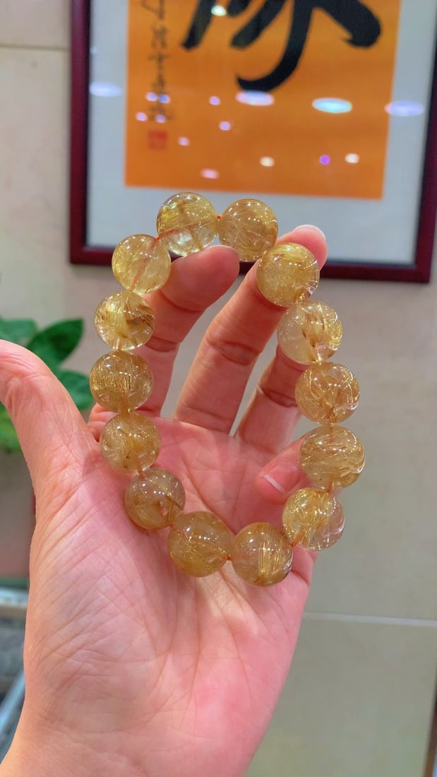 Natural Golden Rutilated Quartz Bracelet: Title: Natural Golden Rutilated Quartz Bracelet Description: This bracelet is a stunning masterpiece showcasing the charming beauty of natural golden rutilated quartz. The golden threads in the bracel
