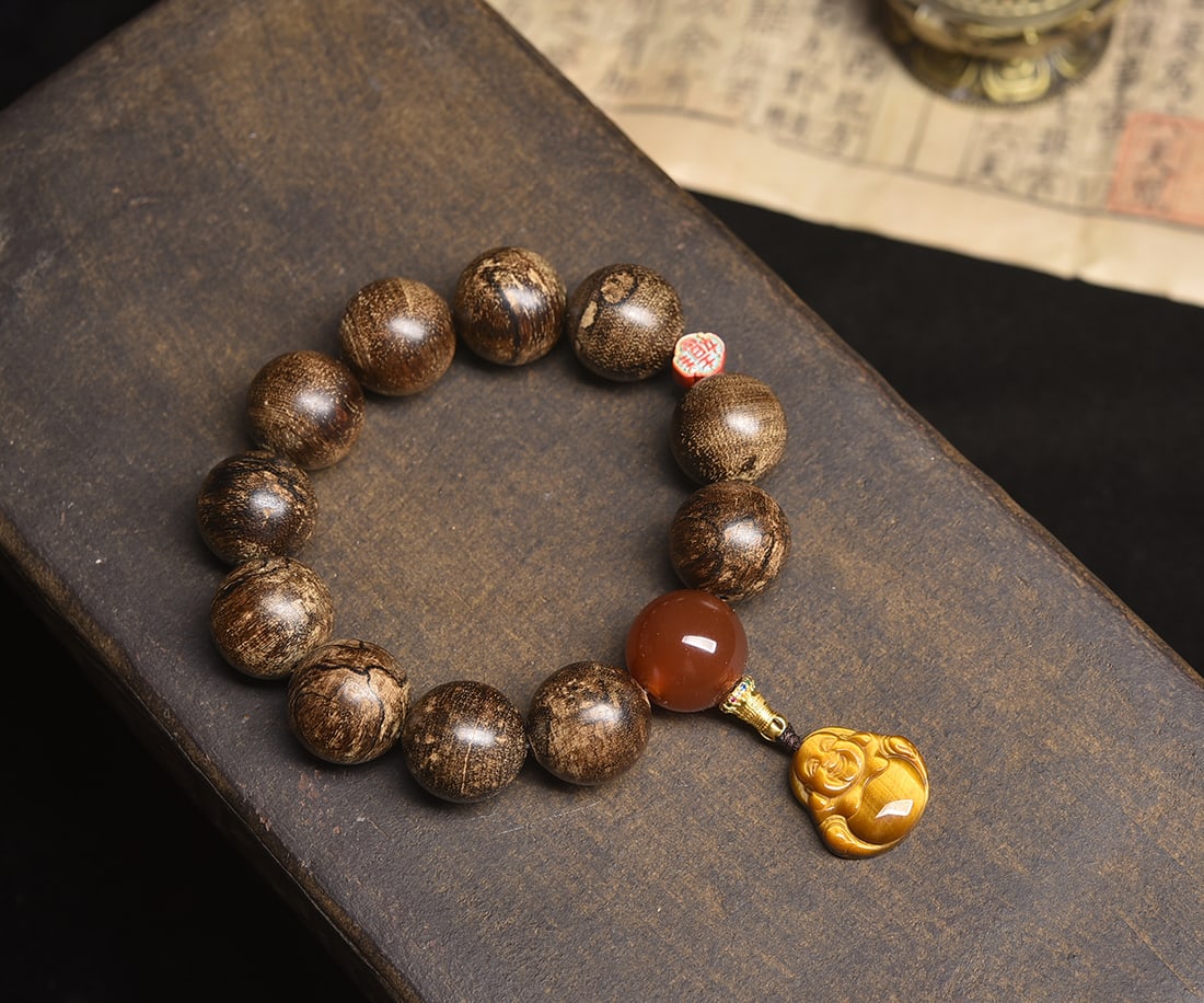 Agarwood Tiger Eye Maitreya Buddha Bracelet: Title: Agarwood Tiger Eye Maitreya Buddha Bracelet Description: This exquisite Maitreya Buddha pendant cleverly combines agarwood and tiger eye stone, with each element carefully selected for its uniq