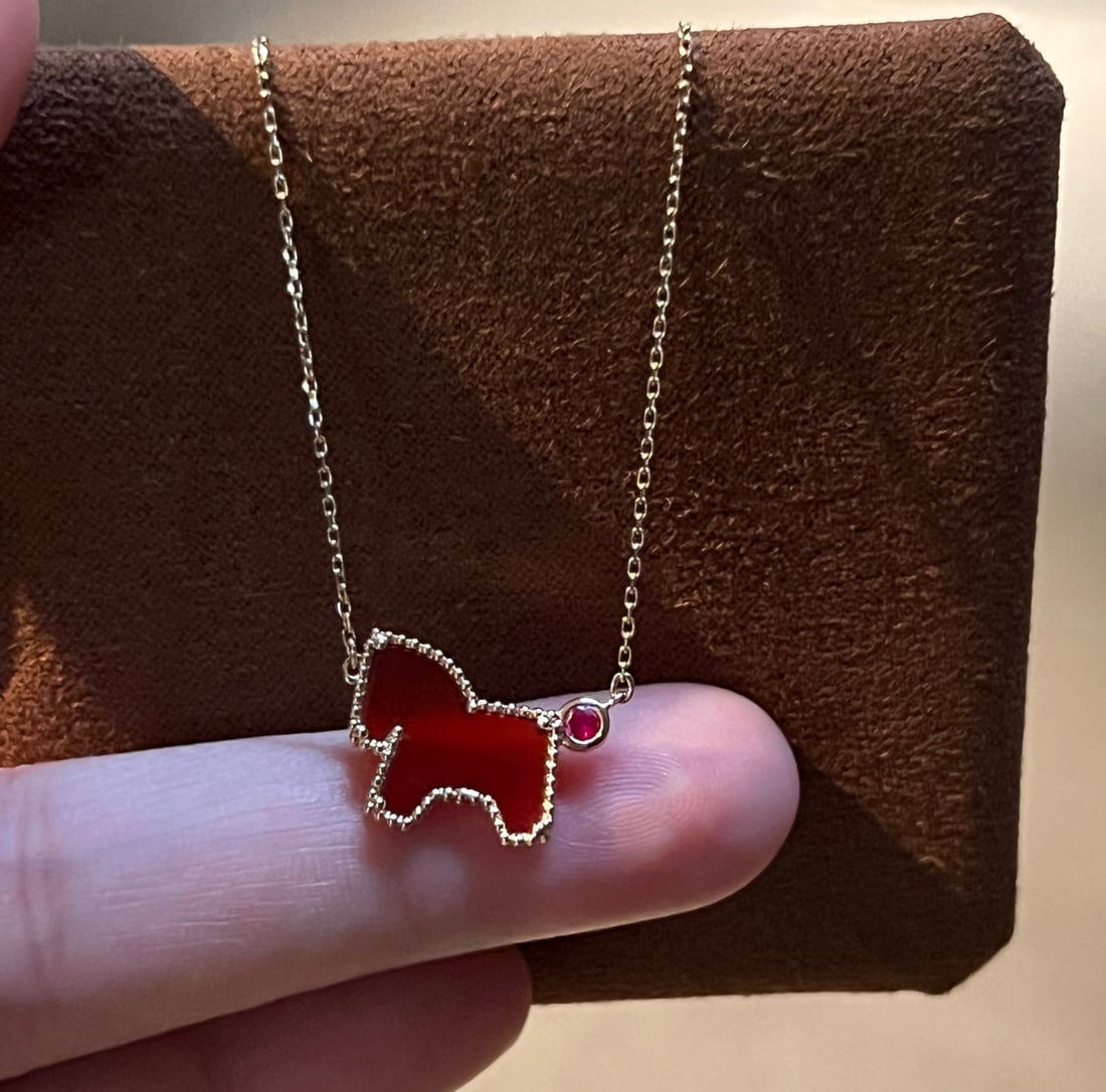 18k Gold Ruby Necklace: Title: 18k Gold Ruby Necklace Description: This necklace features a playful and cute pony design, symbolizing good luck and prosperity. It is adorned with high-quality natural rubies and accented