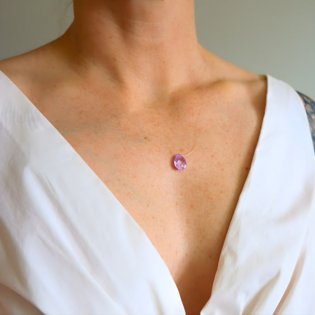 Teardrop Amethyst Necklace: Title:Teardrop Amethyst NecklaceDescription:This dainty amethyst necklace features a faceted pear cut genuine amethyst suspended on a clear line, creating the appearance of a floating gemstone along