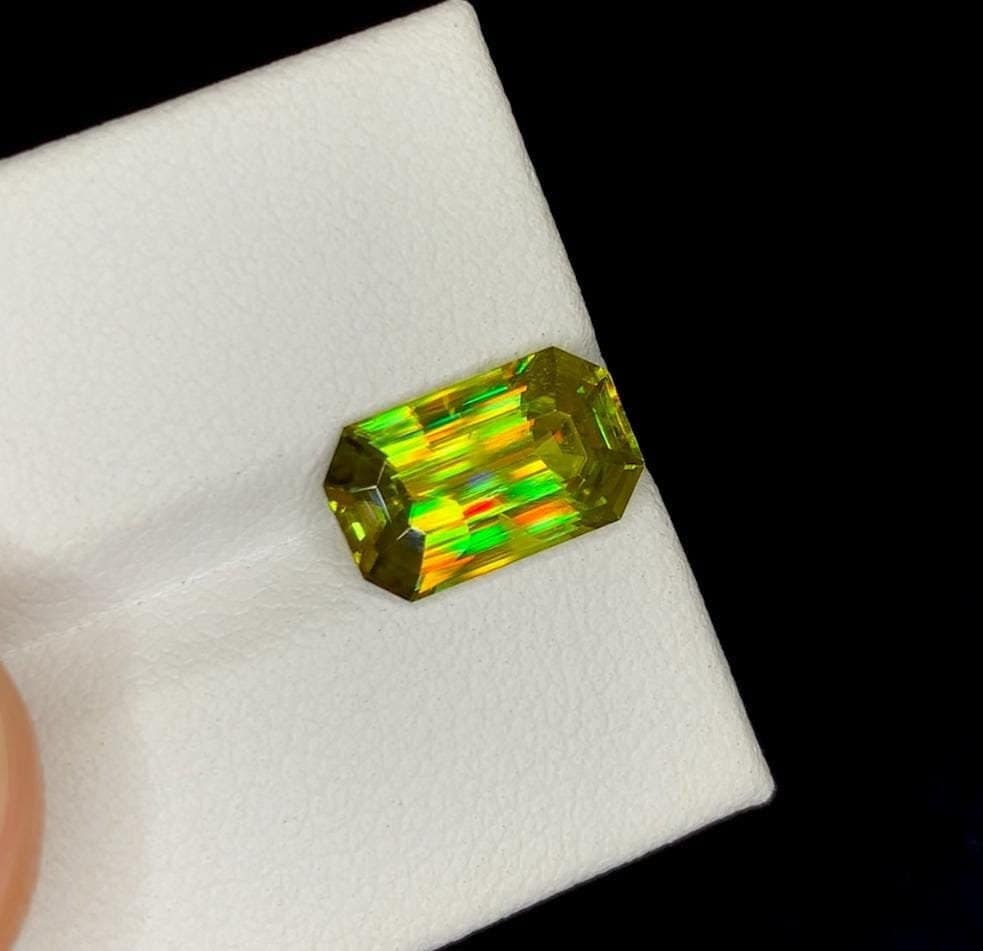 Lustrous Sphene Titanite Fancy Cushion Gemstone: 8.48 Carat Multi Color Titanite, June Birthstone: Materials: Gemstone: Sphene Weight : 8.48 cts Dimensions : 12 * 10.8 * 7.9 MM Color : Multi Color Shape : Cushion Clarity : Clean Treatment : Natural Origin : Africa Hardness : 5-5.5 Family : Titanite