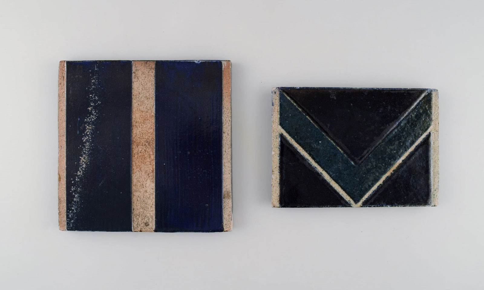 Danish studio ceramicist. Two unique tiles in glazed stoneware. Patterned decoration in dark blue,: Title: Danish studio ceramicist. Two unique tiles in glazed stoneware. Patterned decoration in dark blue, green and sand shades. Late 20th century. Description: Danish studio ceramicist. Two unique