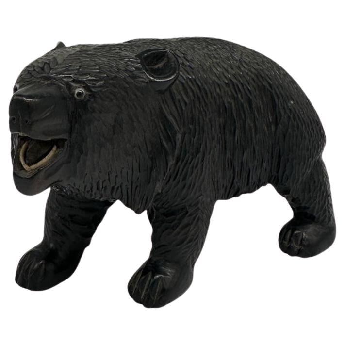 Ainun Black Bear Hand Carved Wood Sculpture with Glass Eyes: Title: Ainun Black Bear Hand Carved Wood Sculpture with Glass Eyes Description: A traditional Ainu bear carving typically depicts a black bear with stylized features, often emphasizing its strength