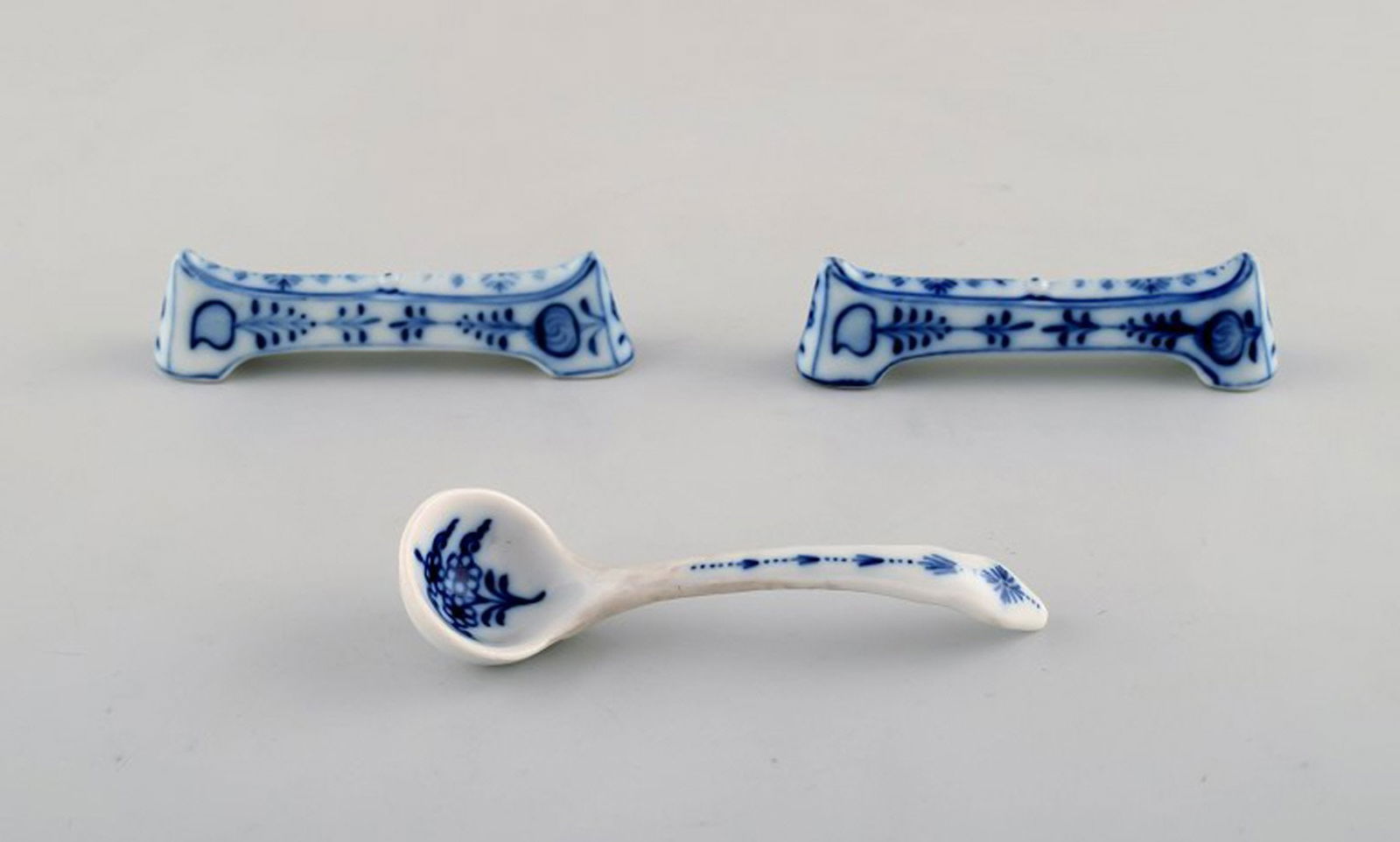 Two Stadt Meissen blue onion patterned knife rests and small spoon. Mid 20th century.: Title: Two Stadt Meissen blue onion patterned knife rests and small spoon. Mid 20th century. Description: Two Stadt Meissen blue onion patterned knife rests and small spoon. Mid 20th century. In very