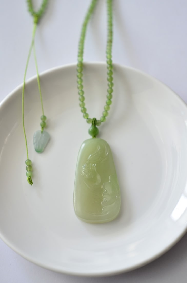 Hetian Jade Hand-Carved Fish,Lotus leaf Pendant: Title: Hetian Jade Hand-Carved Fish,Lotus leaf Pendant Origin: Chinese Date/Period: After2020 Materials: Hetian Jade Dimensions: 48.2x25.5x6.5(mm) 1.90x1.00x0.26(inches) Reserve: $499.00 Shipping: D