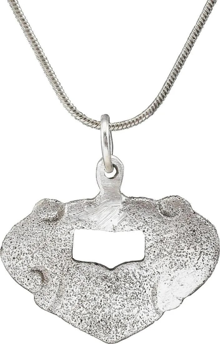 VIKING HEART PENDANT C.900-1050 AD: About 3/4" height plus the loop, flat with scrolls forming the sides and defining the cusp. Rectangular form central piercing. The foliate trefoil was a very popular motif for Viking hearts. The form