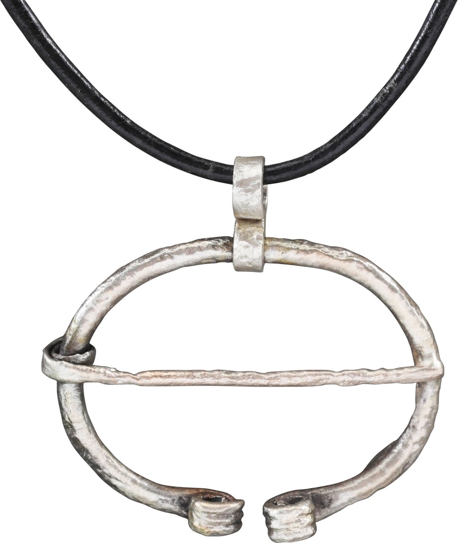 VIKING PROTECTIVE BROOCH, 850-1050 AD.: Over 1 1/2" width, oval form with the ends reeded and curled. Original cross pin. Worn in numbers on the leather war jerkin, at an ounce each, a few pounds could be added providing significant protect