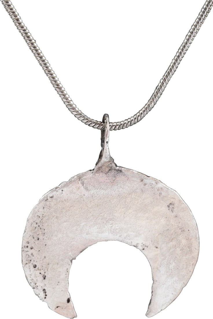 VIKING LUNAR PENDANT NECKLACE, 9th-10th CENTURY: Silvered bronze, of fine broad curved form. As expert navigators, the constellations signified mystery and power to Vikings. Lunar pendants were worn as pectorals as well as suspended from belts, othe